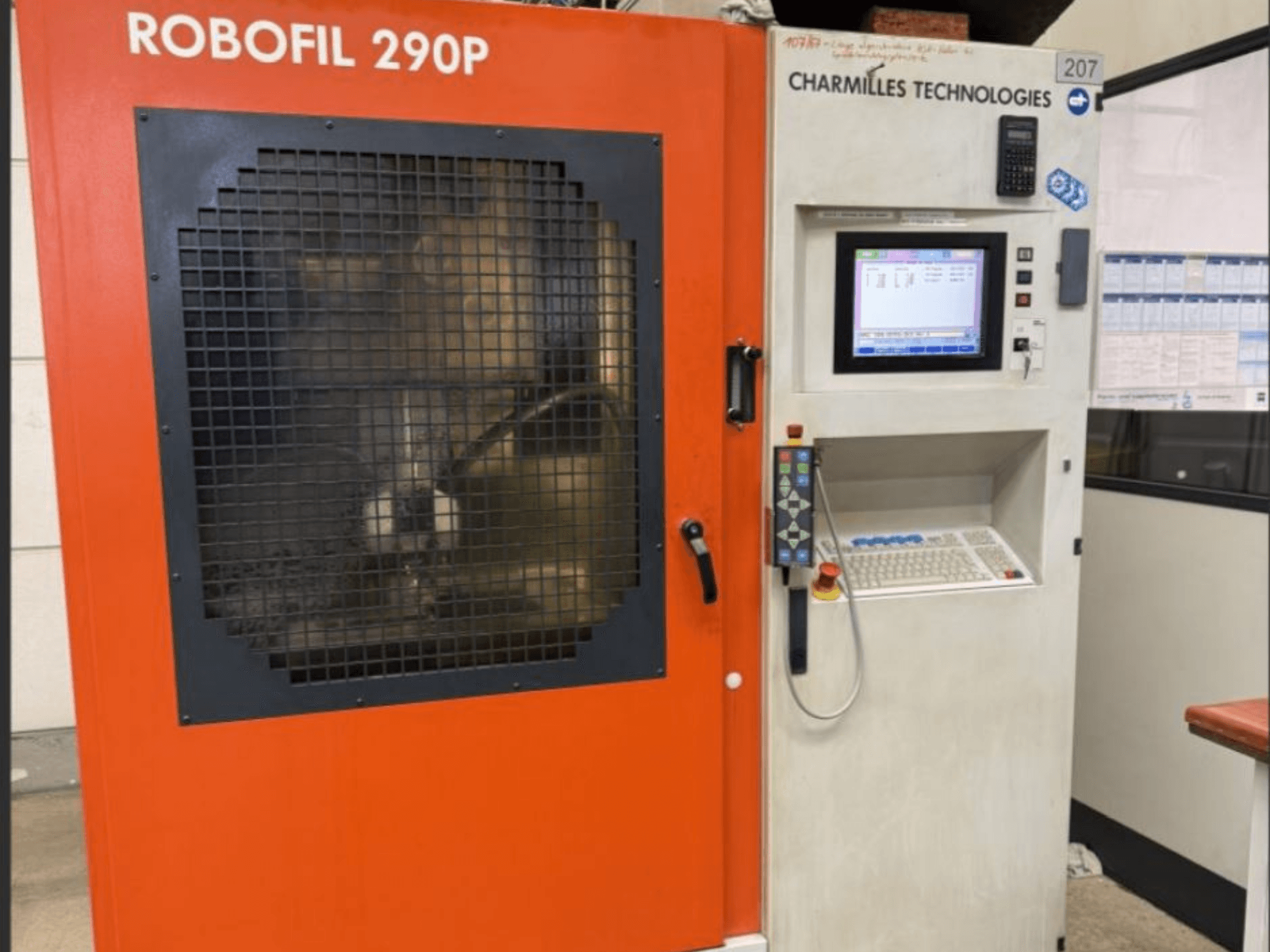 CHARMILLES TECHNOLOGIES Robofil 290P vielos EDM staklių vaizdas iš priekio su valdymo pultu ir tinkleliu apsaugota darbo zona.