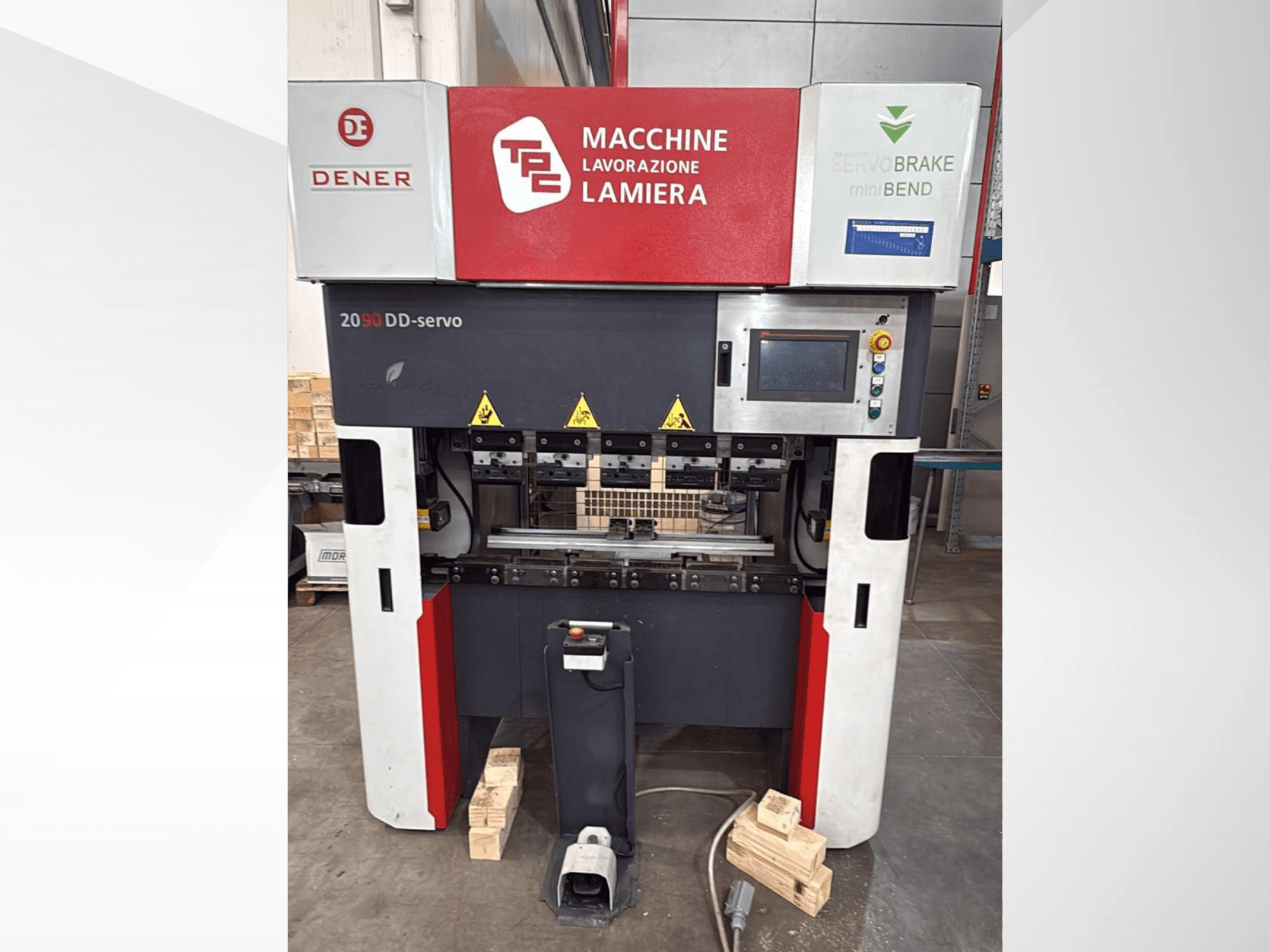 DENER DDS 2090 lenkimo presas, vaizdas iš priekio, su valdymo pultu, saugos etiketėmis ir mediniu pagrindu.