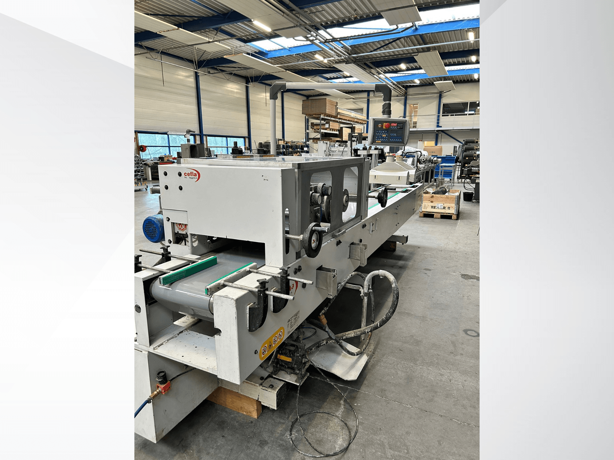 CEFLA „Smartparquet MRF-2VS/300“ medienos apdirbimo staklių vaizdas iš priekio, kuriame matomas valdymo pultas ir konvejeris su žaliais ritiniais.