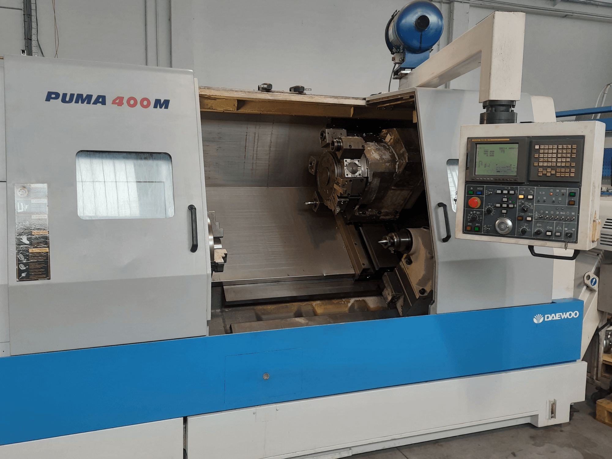 „DAEWOO PUMA 400MB“ horizontalios tekinimo staklių vaizdas iš priekio, kuriame matomi valdymo elementai ir pjovimo įrankis kameroje.