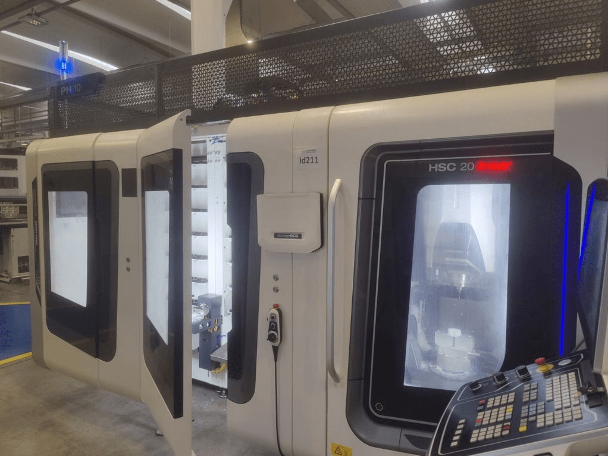 DMG MORI HSC 20 vertikalusis apdirbimo centras, vaizdas iš priekio, matomos atidarytos durys, pro kurias matyti apdirbimo vidus ir valdymo skydelis.