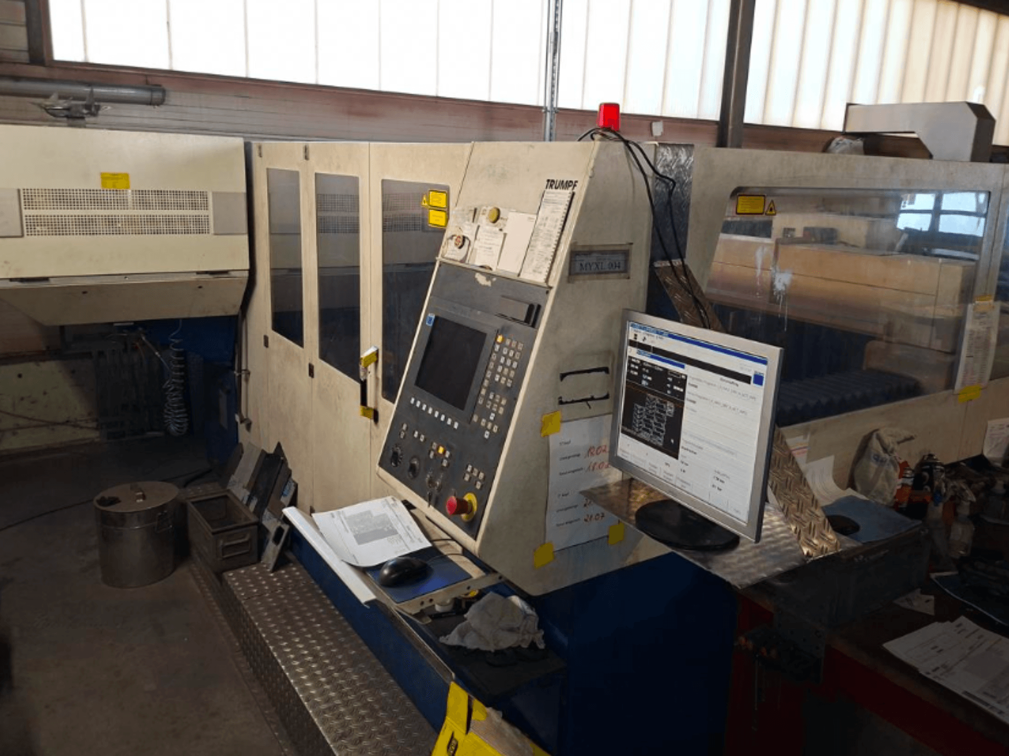 TRUMPF Trumatic L 4030 CO2 lazerinio pjaustymo staklės, priekinis vaizdas, kuriame matomas valdymo skydelis ir monitorius, matomos darbo vietos detalės.