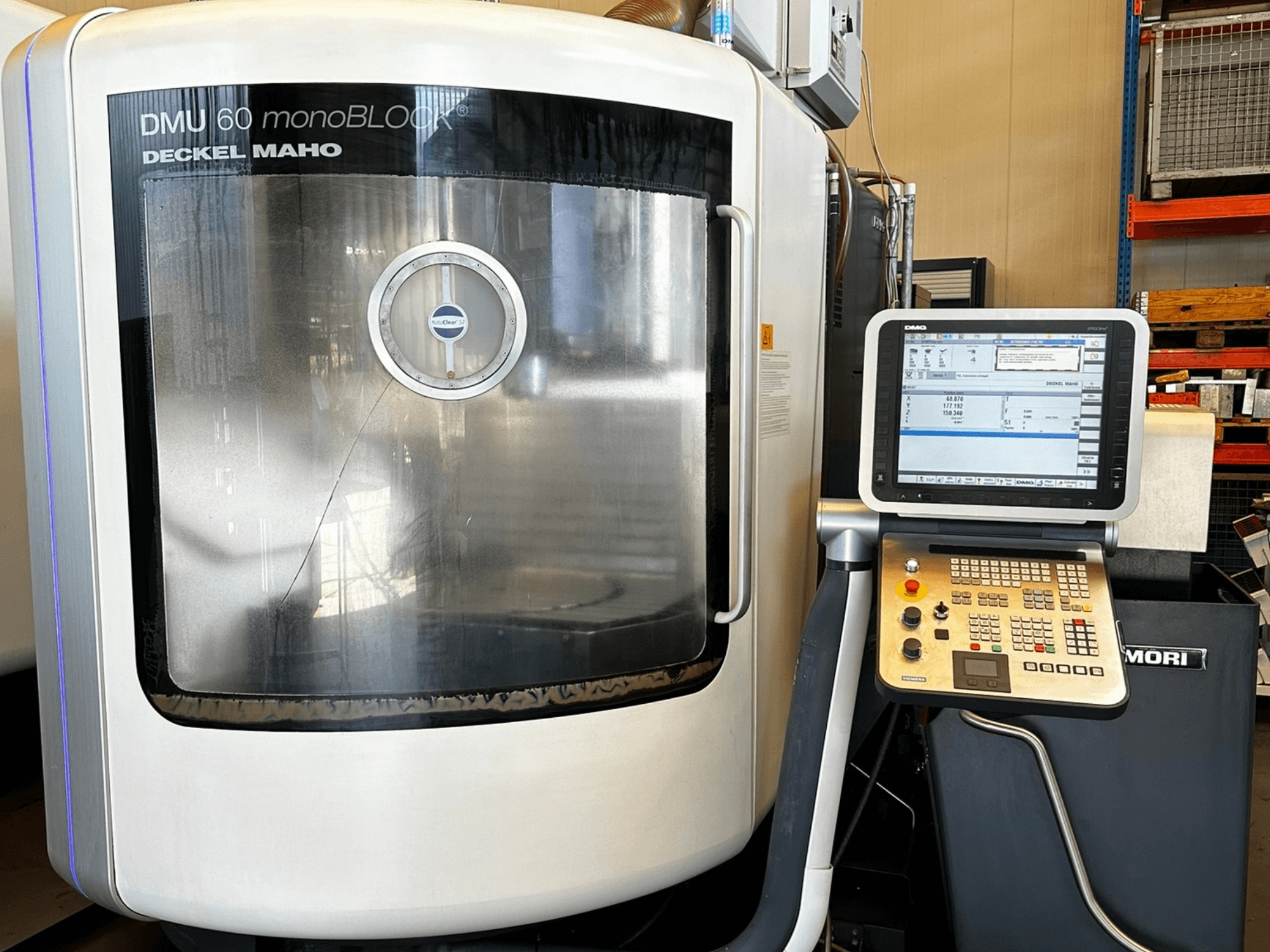 DMG MORI DMU 60 monoBLOCK vertikalusis apdirbimo centras, priekinis vaizdas, jutiklinio ekrano valdymo skydelis ir atspindintis langas.