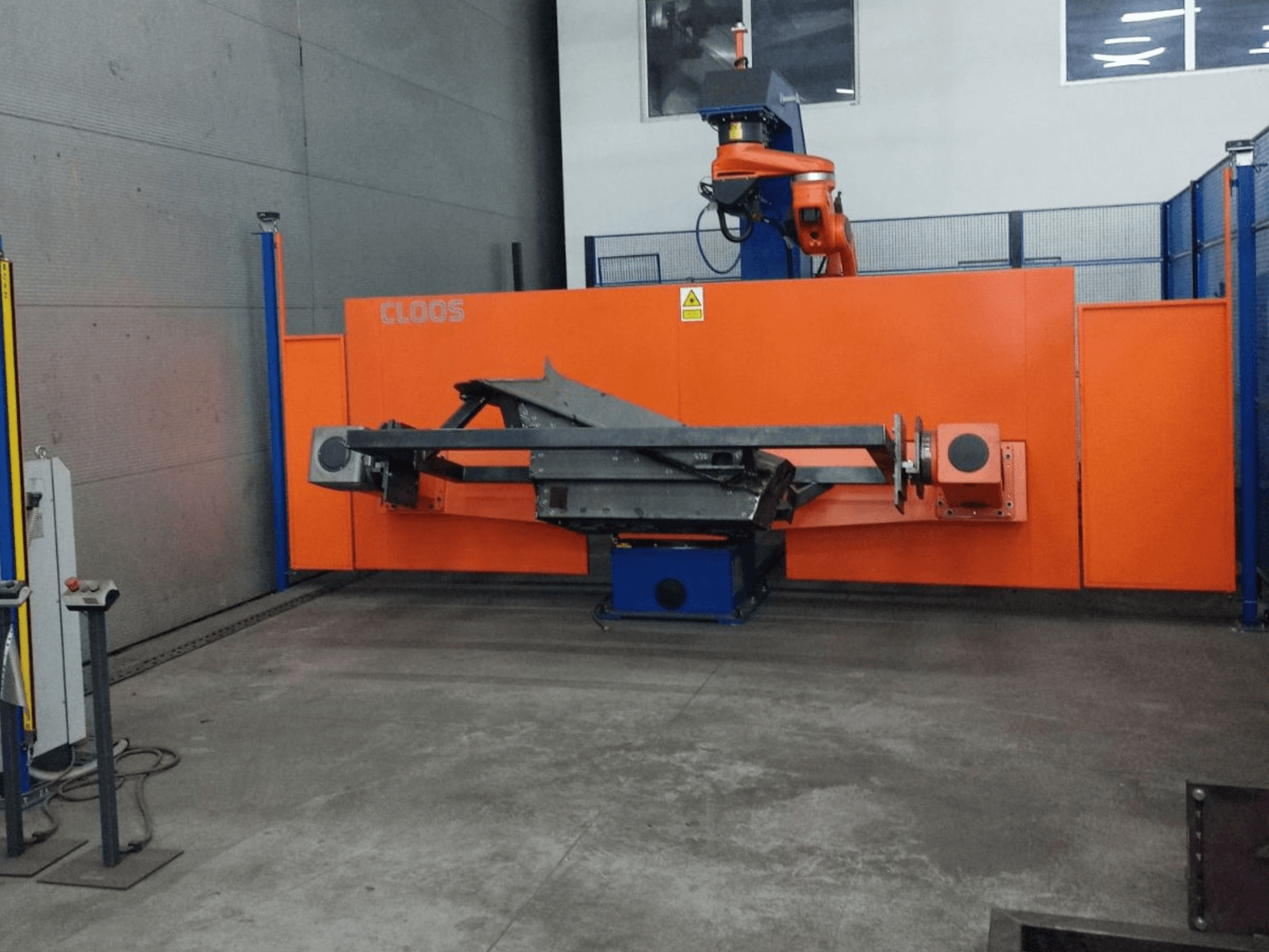 CLOOS QIROX QRC-350-E automatizavimo sistemos su roboto ranka ir metalo konstrukcijos konstrukcija pramoninėje aplinkoje vaizdas iš priekio.