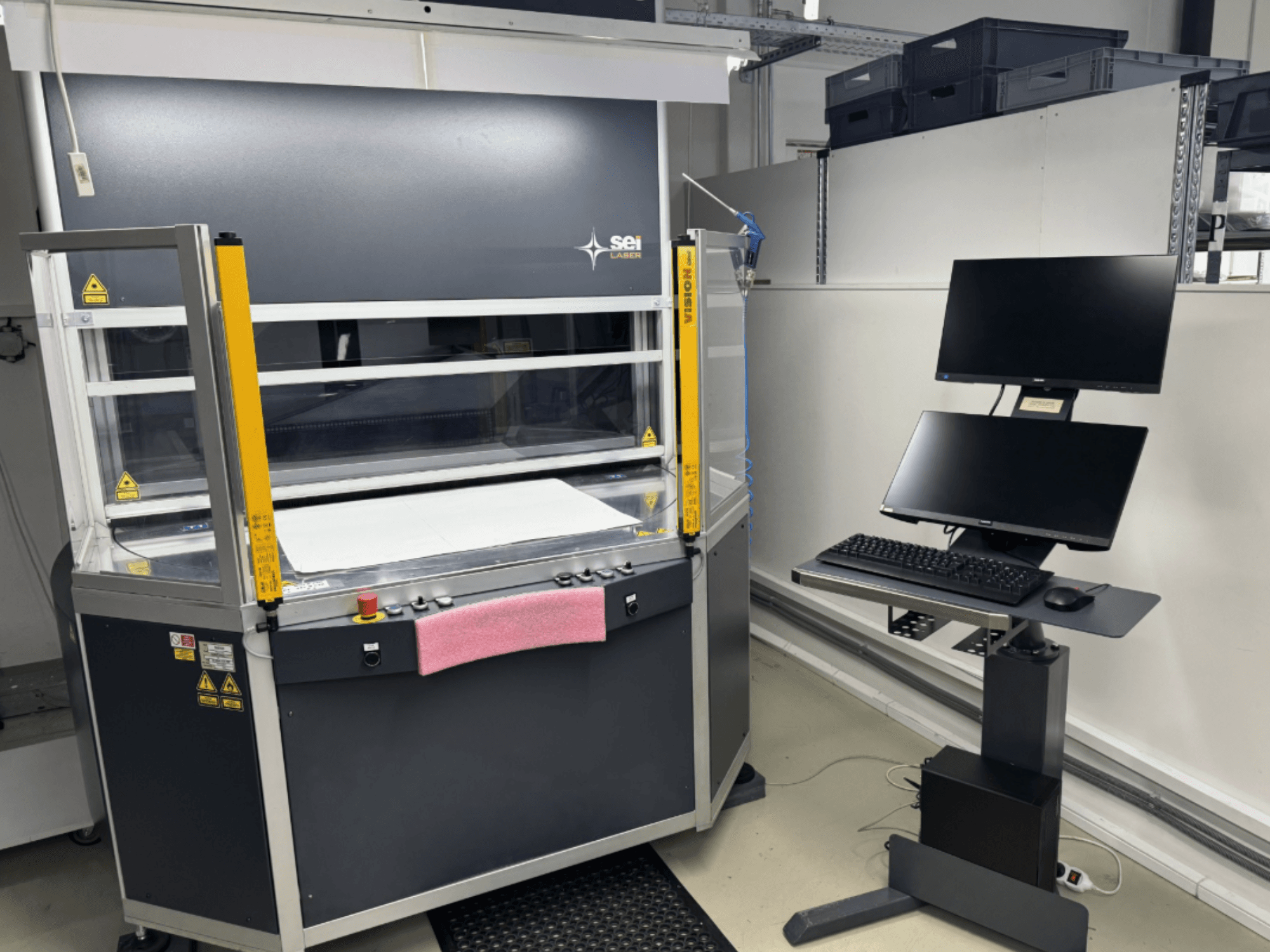 SEI Laser INFINITY 5070 V300 CO₂ lazerinio pjovimo staklės, vaizdas iš priekio, su valdymo pultu ir prijungta monitoriaus stotele.