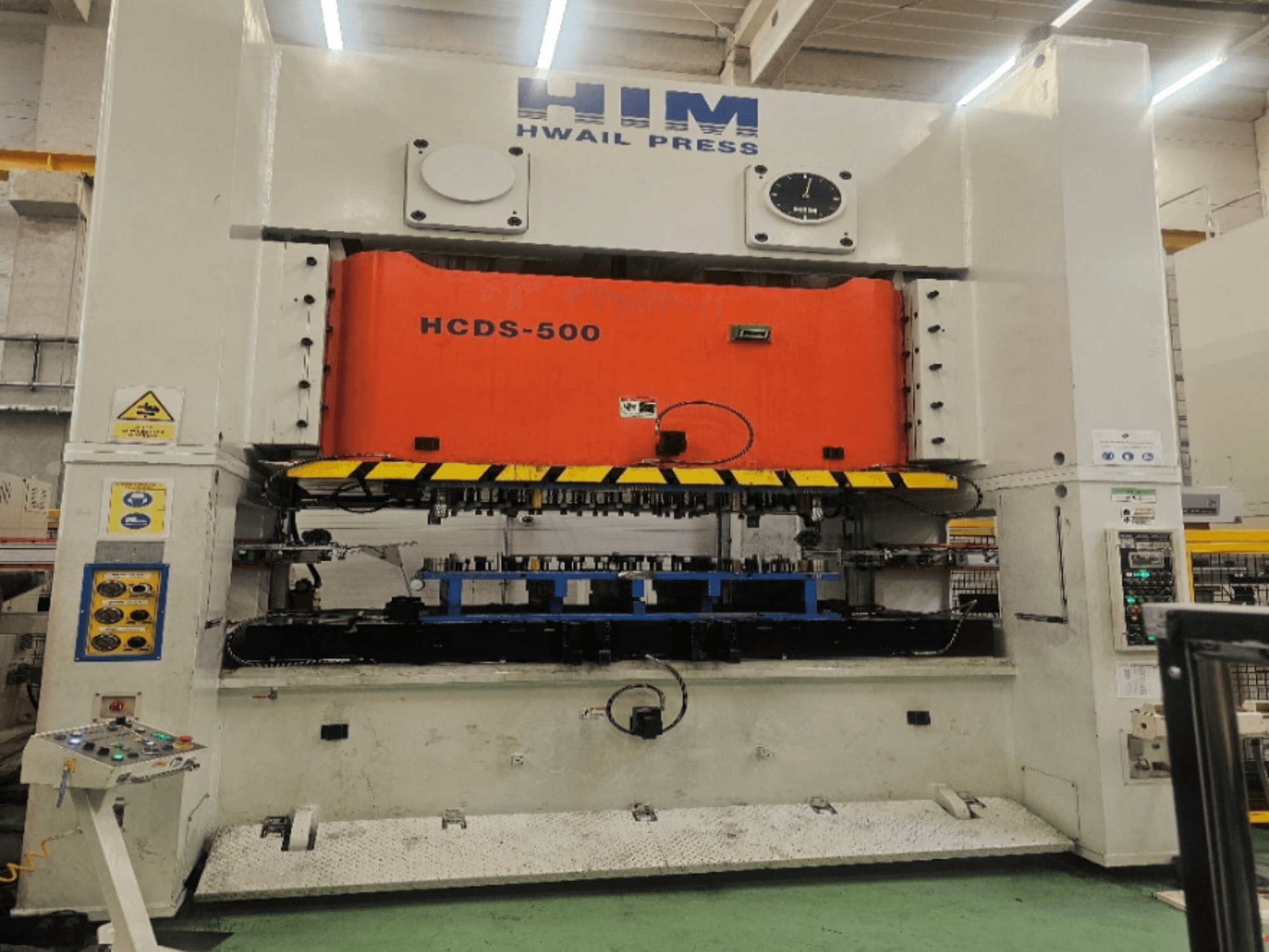 Mechaninė štampavimo presas „HIM HWAIl PRESS HCDS-500“, vaizdas iš priekio, su oranžine presavimo plokšte ir valdymo pultu.