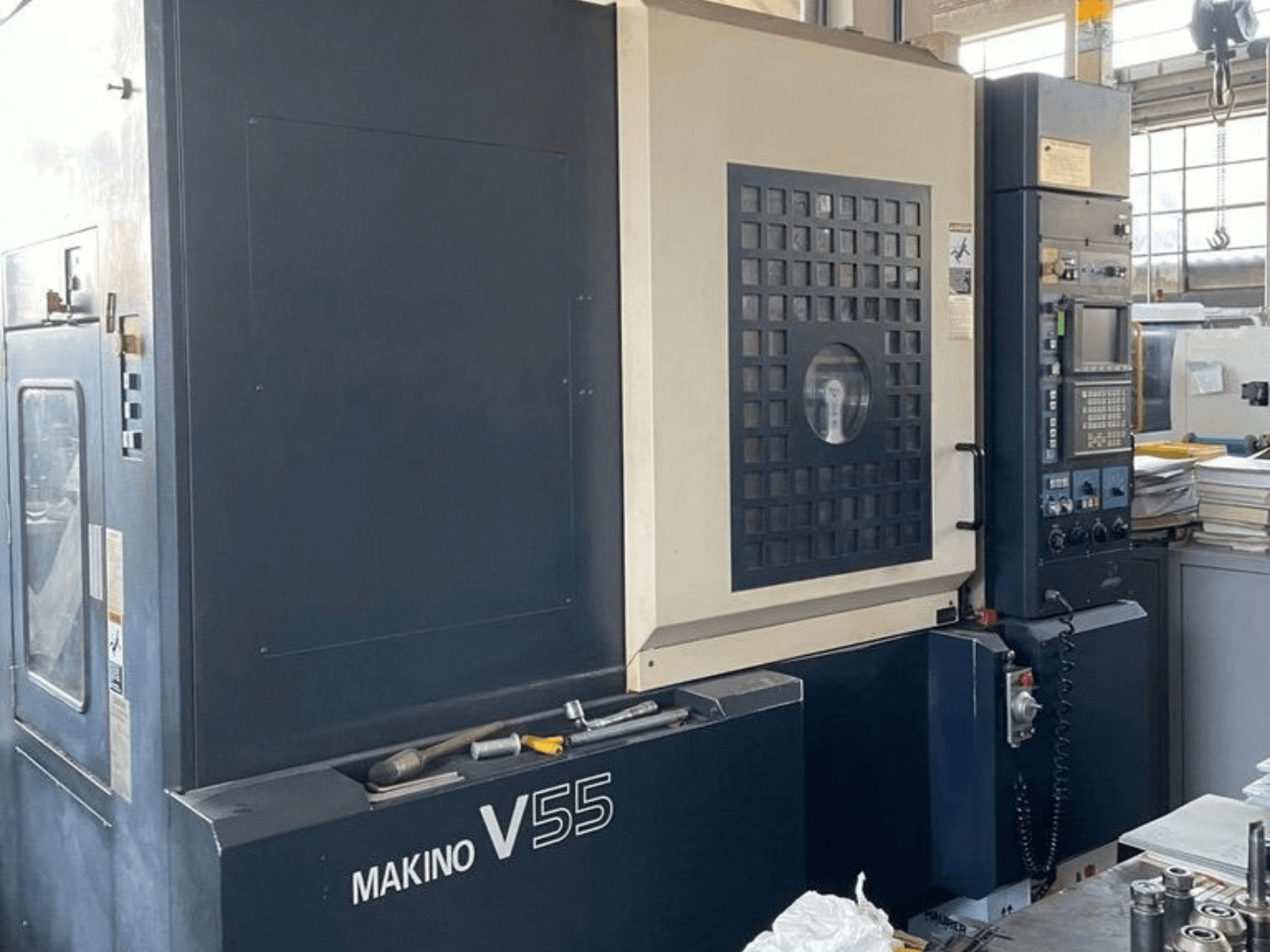 Vertikalusis apdirbimo centras „Makino V55-A15“, vaizdas iš priekio, kuriame matomas valdymo skydas, tvirta konstrukcija ir darbo vietos išdėstymas.