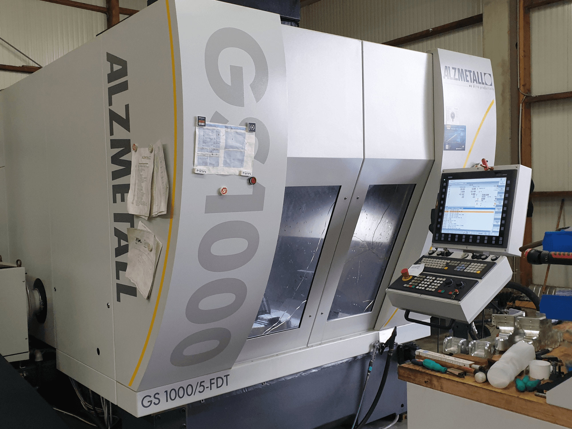 Vertikalaus apdirbimo centras „Alzmetall GS 1000/5-FDT“, vaizdas iš priekio, kuriame matomas valdymo pultas ir darbo erdvė.
