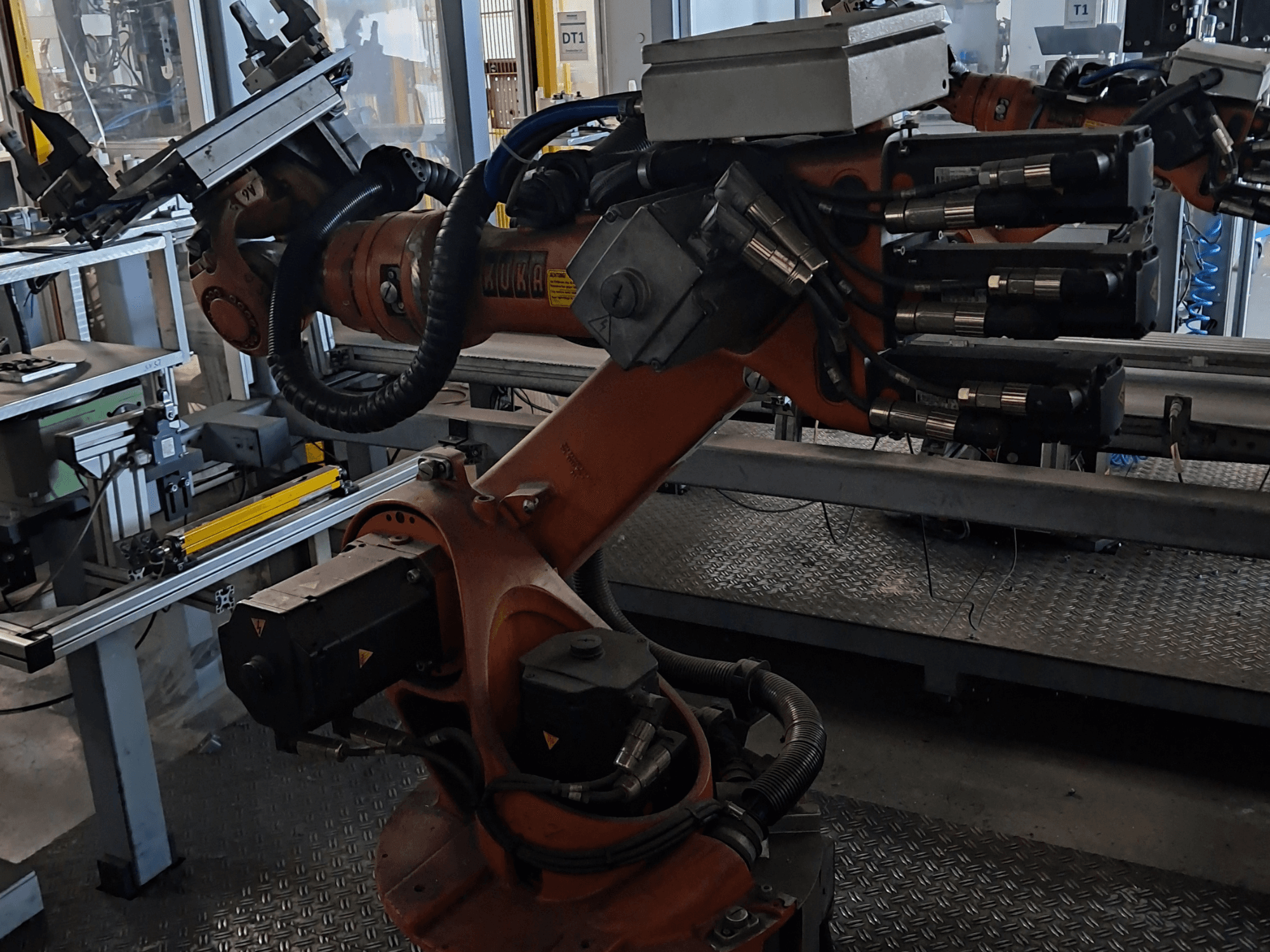 „KUKA KR 16-2“ roboto ranka su „KRC 4“ valdikliu, vaizdas iš šono, kuriame matomi lankstieji sąnariai ir hidraulinės jungtys.