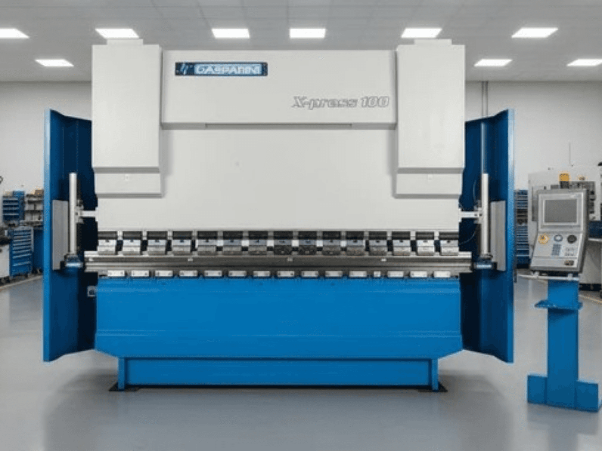 Hidraulinė presavimo mašina „GASPARINI X-Press 100“, vaizdas iš priekio, su mėlynos spalvos korpusu ir valdymo pultu dešinėje pusėje.