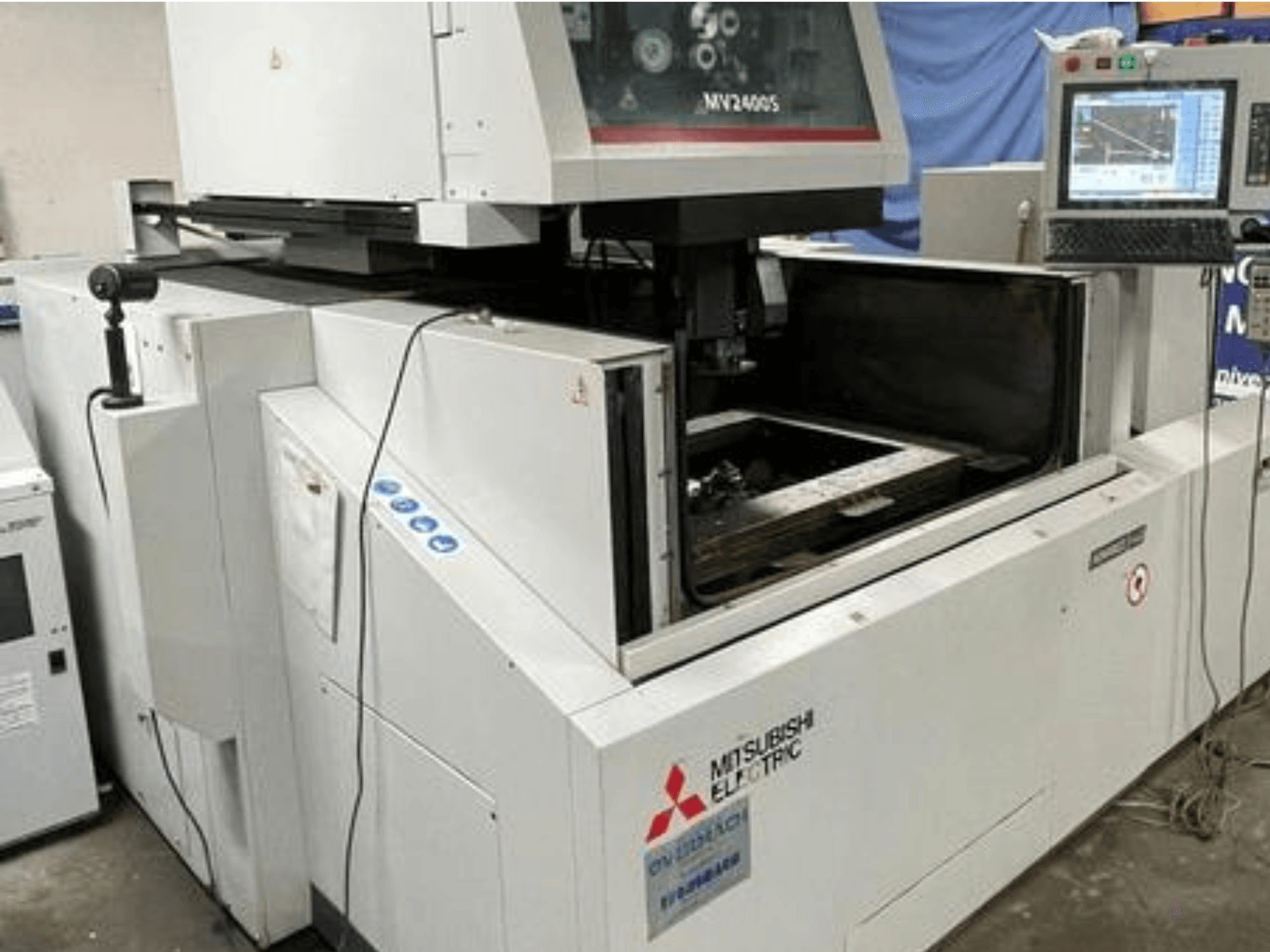 "Mitsubishi Electric MV2400S" vielos pjovimo EDM staklės, priekinis vaizdas, kuriame matomas valdymo skydelis ir atvira darbo zona.