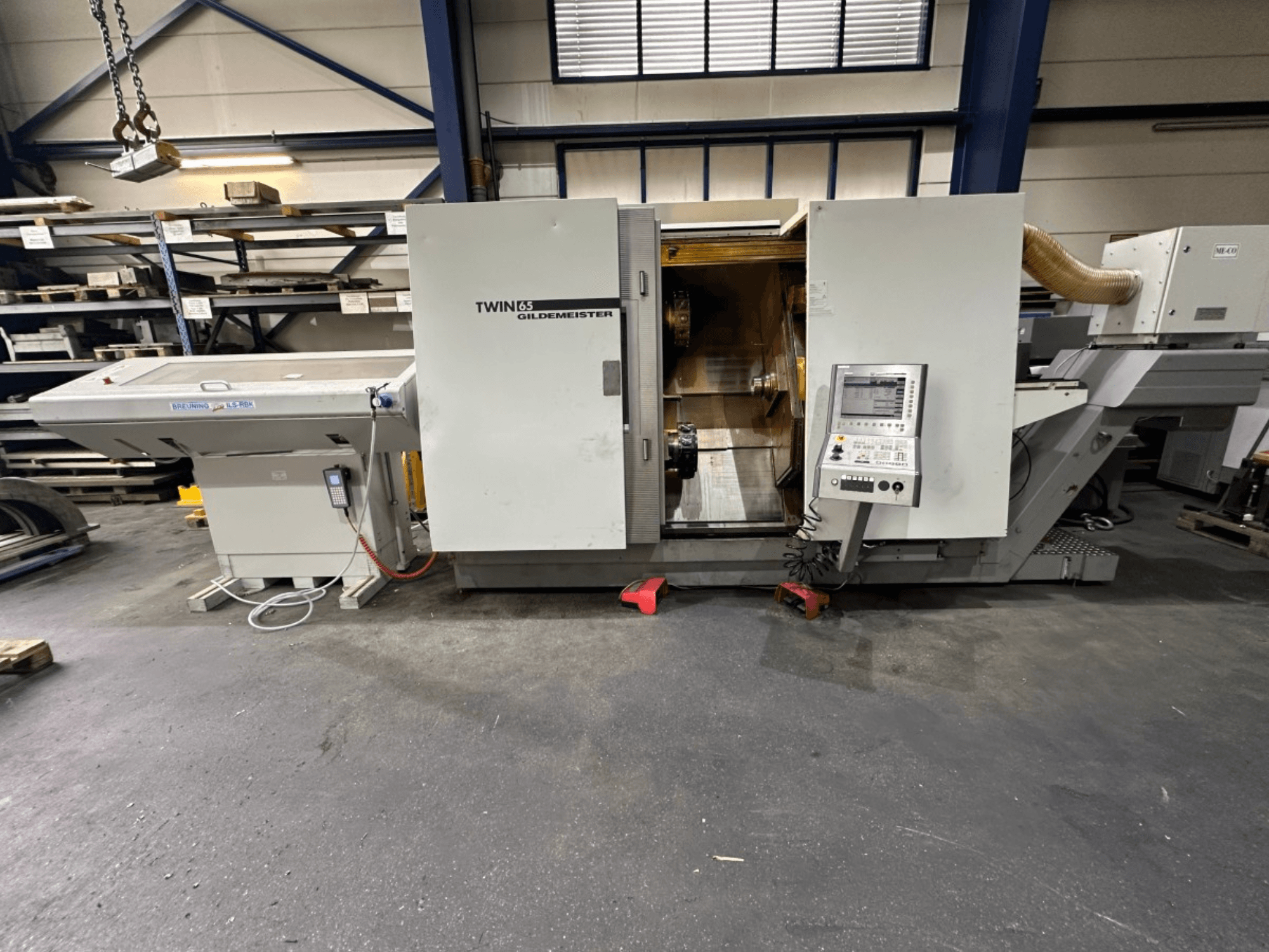 Horizontaliosios tekinimo staklės "Gildemeister TWIN 65", vaizdas iš priekio; valdymo skydelis ir matomas detalių apdirbimo vidus.