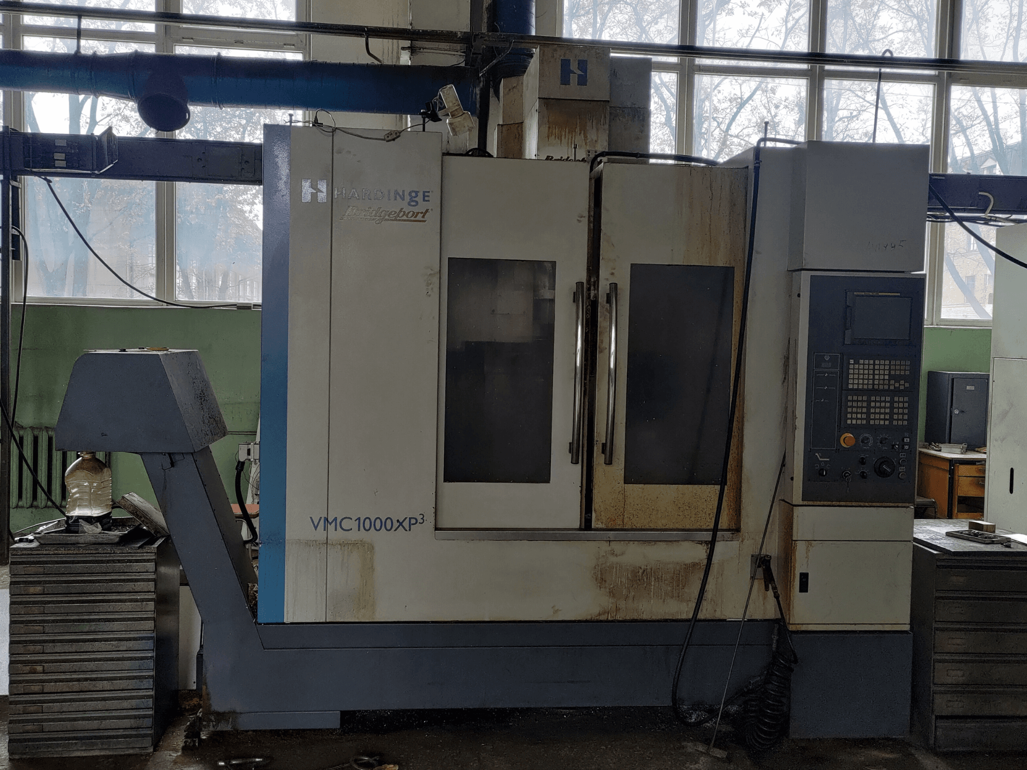 Vertikalus apdirbimo centras „Bridgeport VMC1000 XP3“, vaizdas iš priekio, kuriame matomas valdymo pultas ir nežymus nusidėvėjimas.