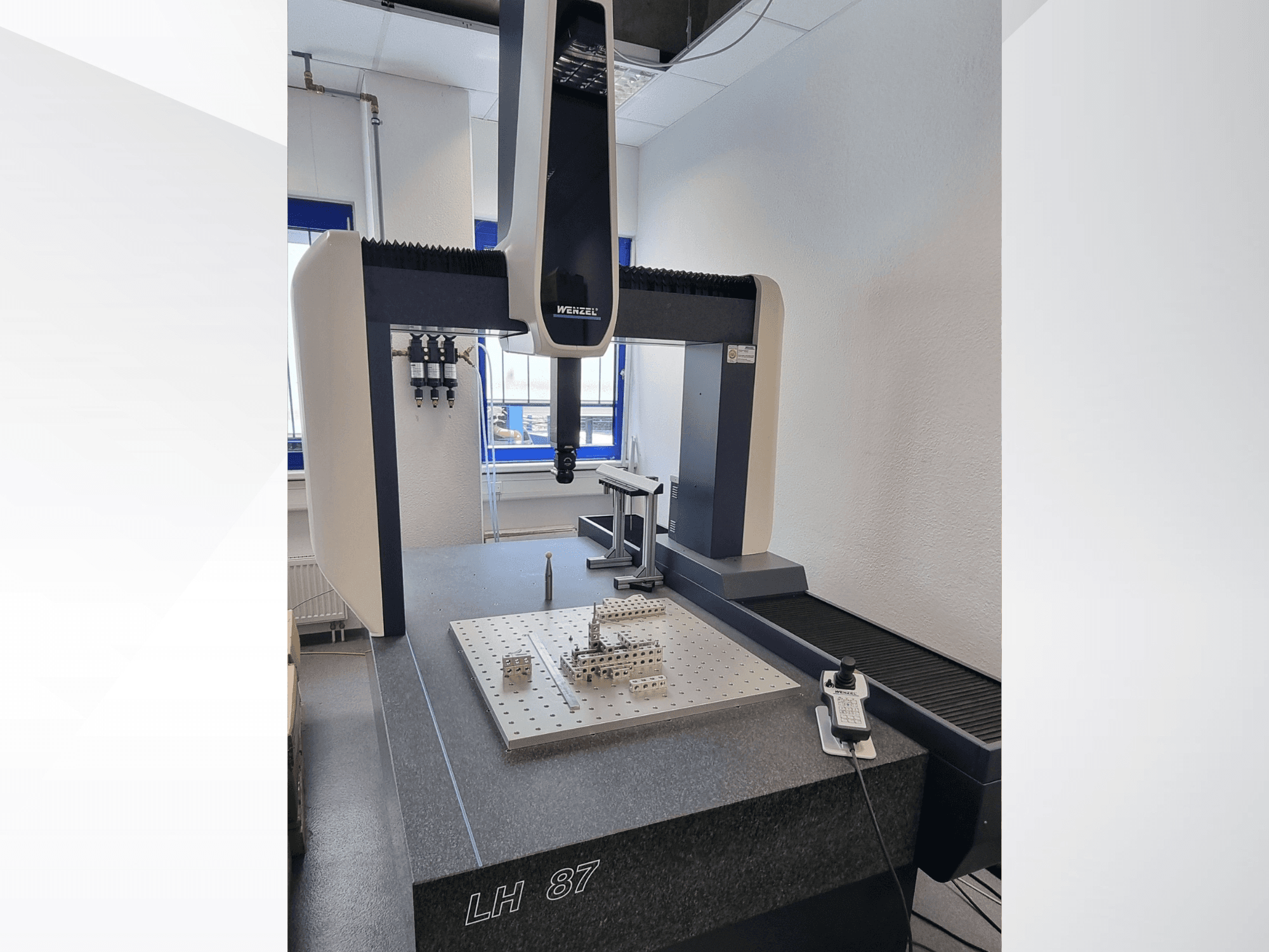 „Wenzel LH 87 CMM“ laboratorijoje, vaizdas iš priekio: matomas matavimo zondas, esantis virš tiksliosios matavimo plokštės, ir skaitmeninis valdiklis.