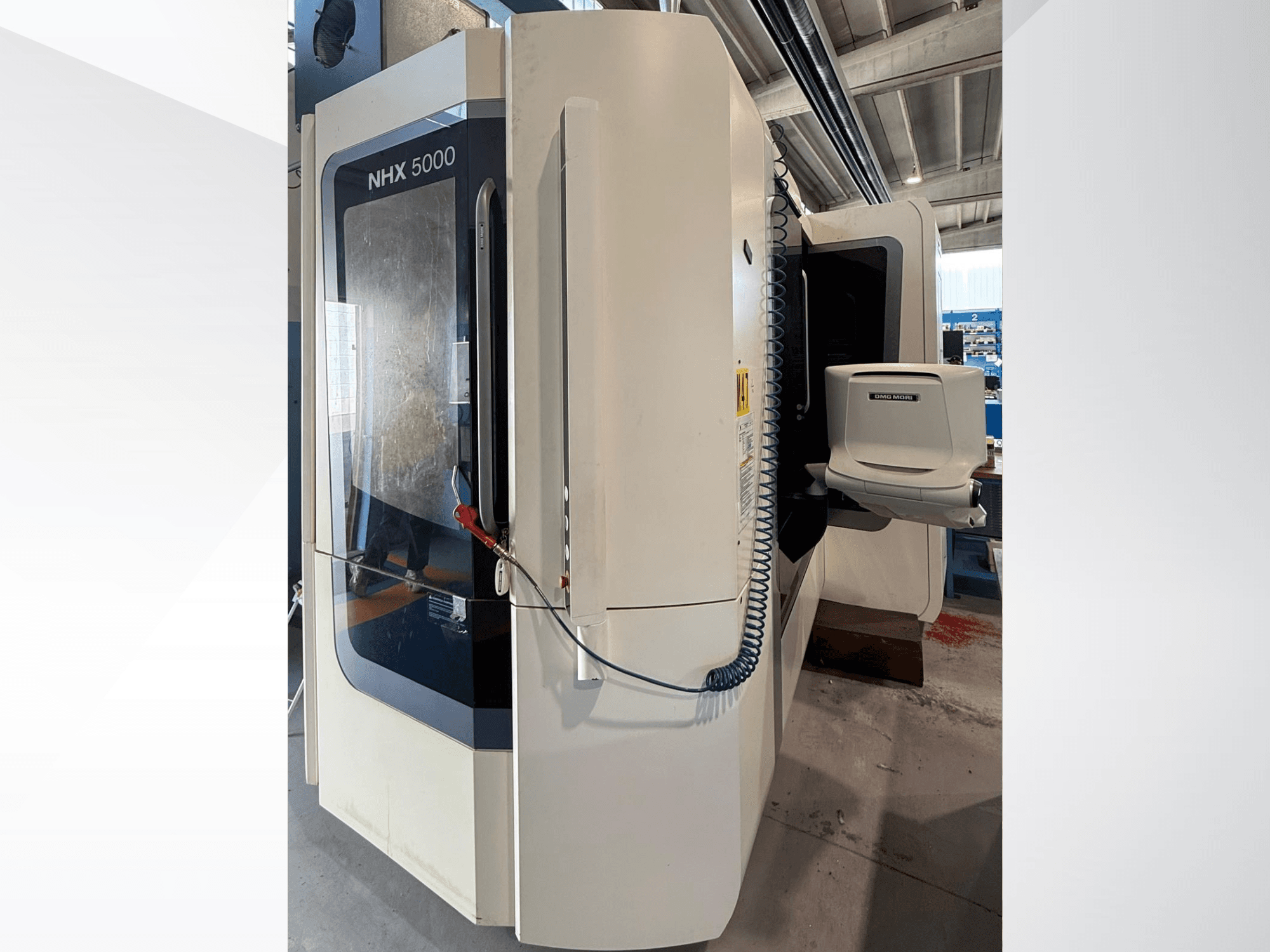 DMG MORI NHX 5000 horizontalusis tekinimo staklės, vaizdas iš priekio, kuriame matomas valdymo pultas ir suklio laikiklis.