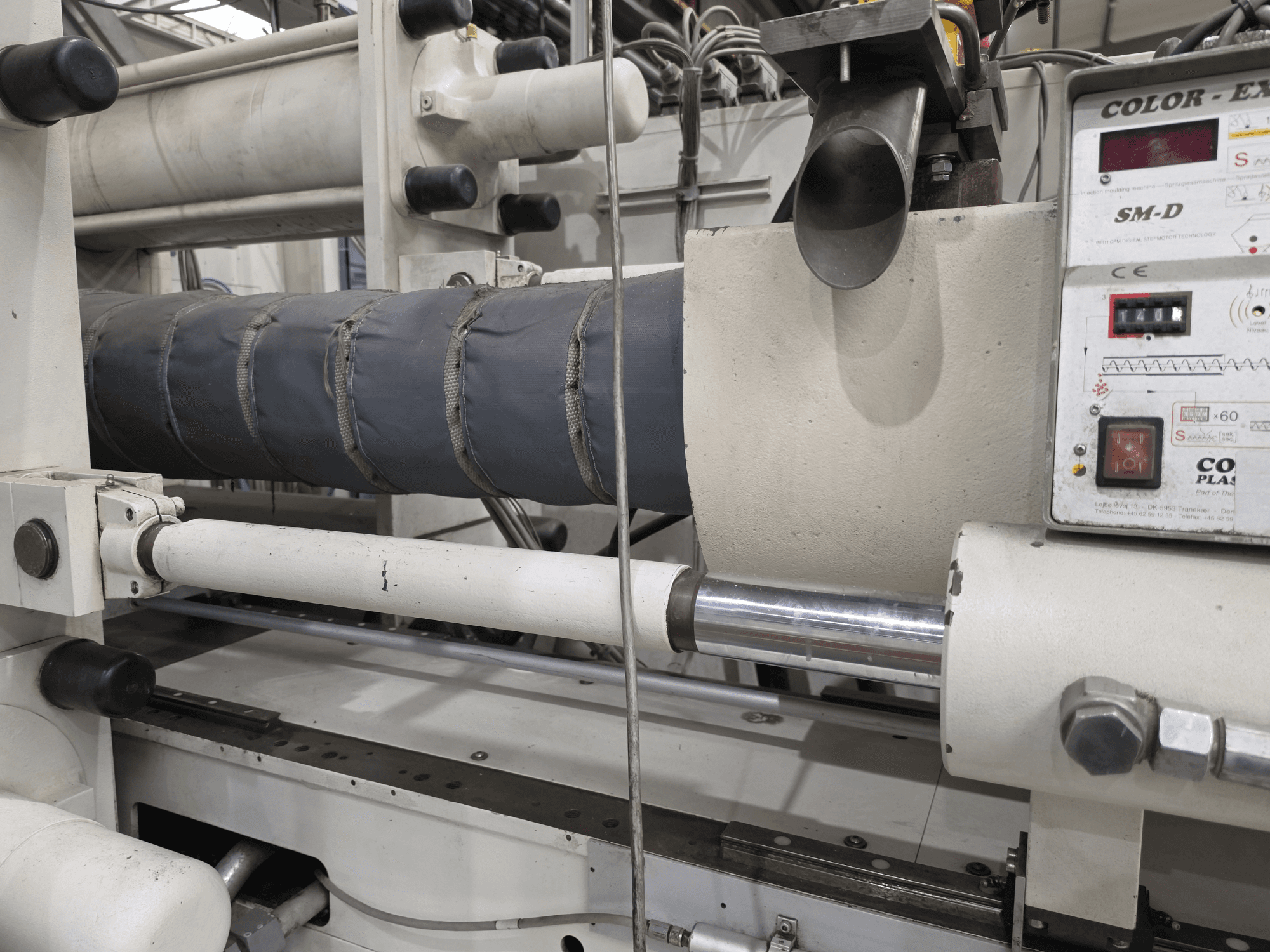 Krauss Maffei 350-3000 CX hidraulinė liejimo mašina, šoninis vaizdas, kuriame matyti temperatūros valdymo skydelis ir kaitinimo elementai.