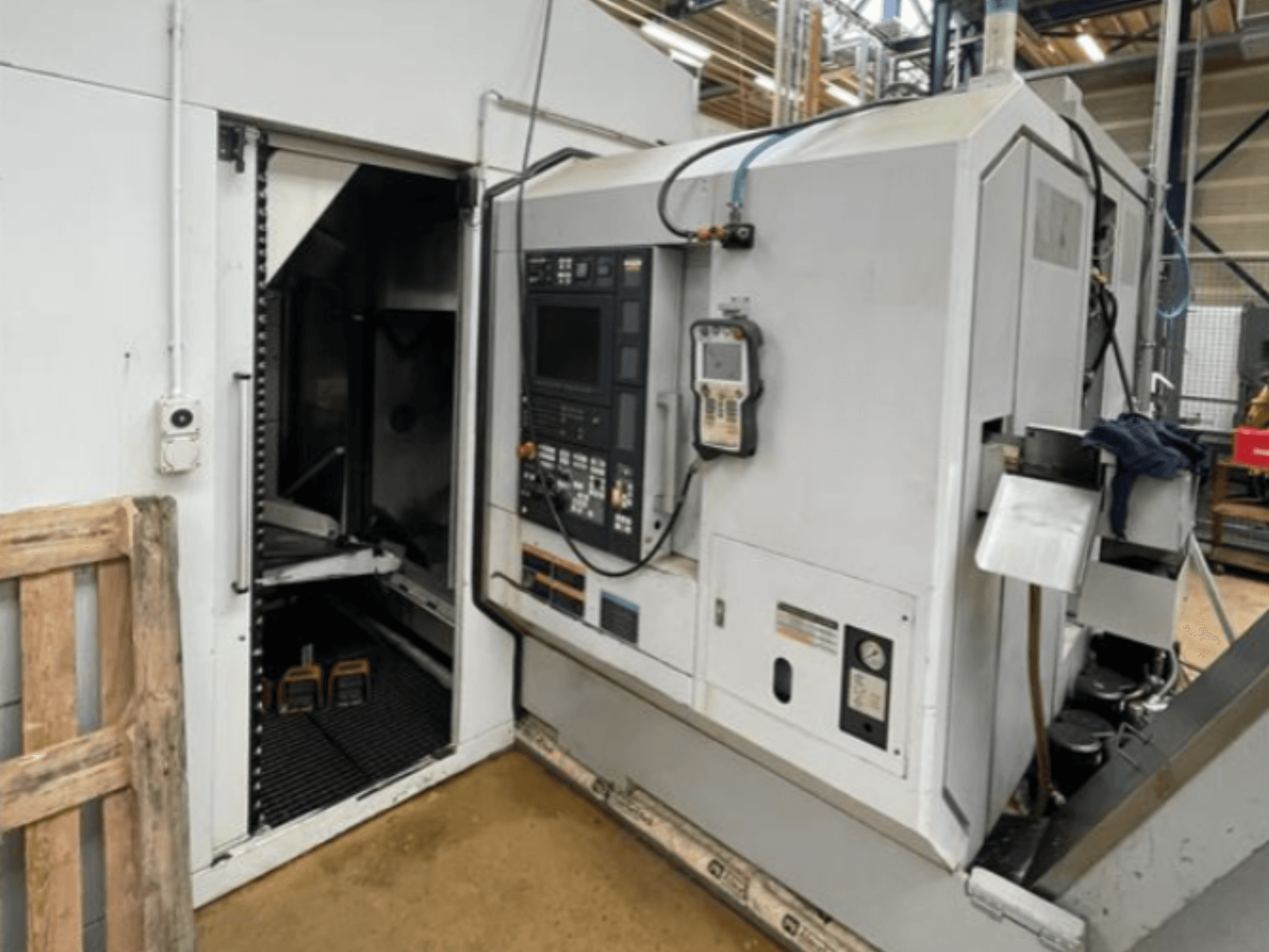DMG Mori Seiki NZ2000T3Y2 horizontalios tekinimo staklės, šoninis vaizdas, kuriame matomas valdymo skydelis ir staklių vidus.