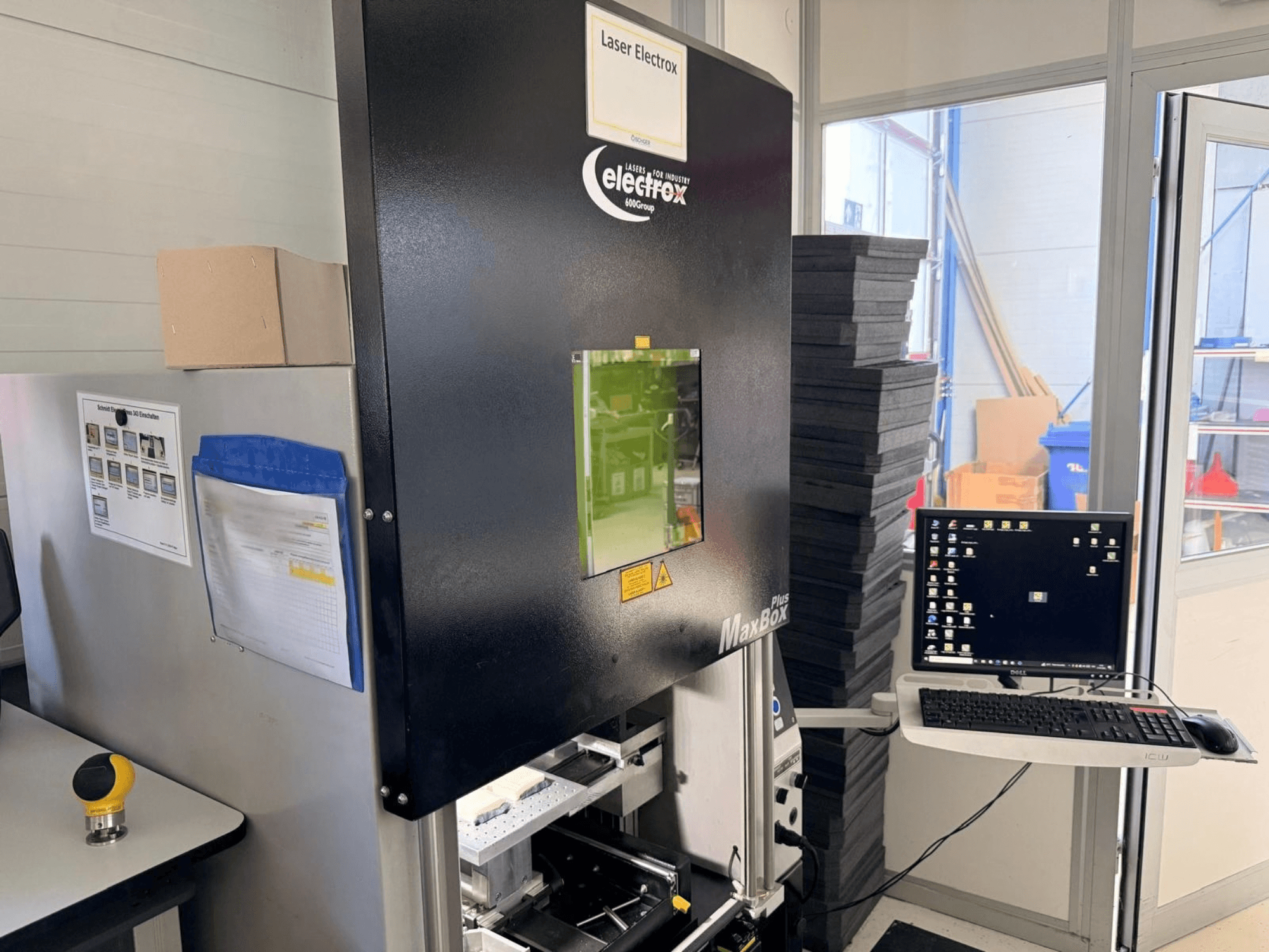 „ELECTROX MaxBox Plus“ lazerinio ženklinimo staklės, matomos iš šono: matomas valdymo monitorius, žalias peržiūros langelis ir darbo erdvė.
