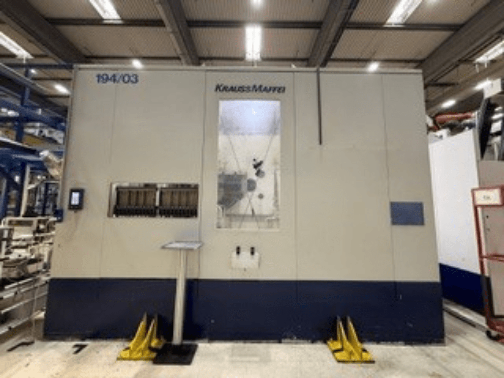 „Krauss Maffei 4000-24500 MC“ hidraulinio liejimo staklių vaizdas iš priekio, kuriame matomas valdymo skydas ir valdymo elementai.