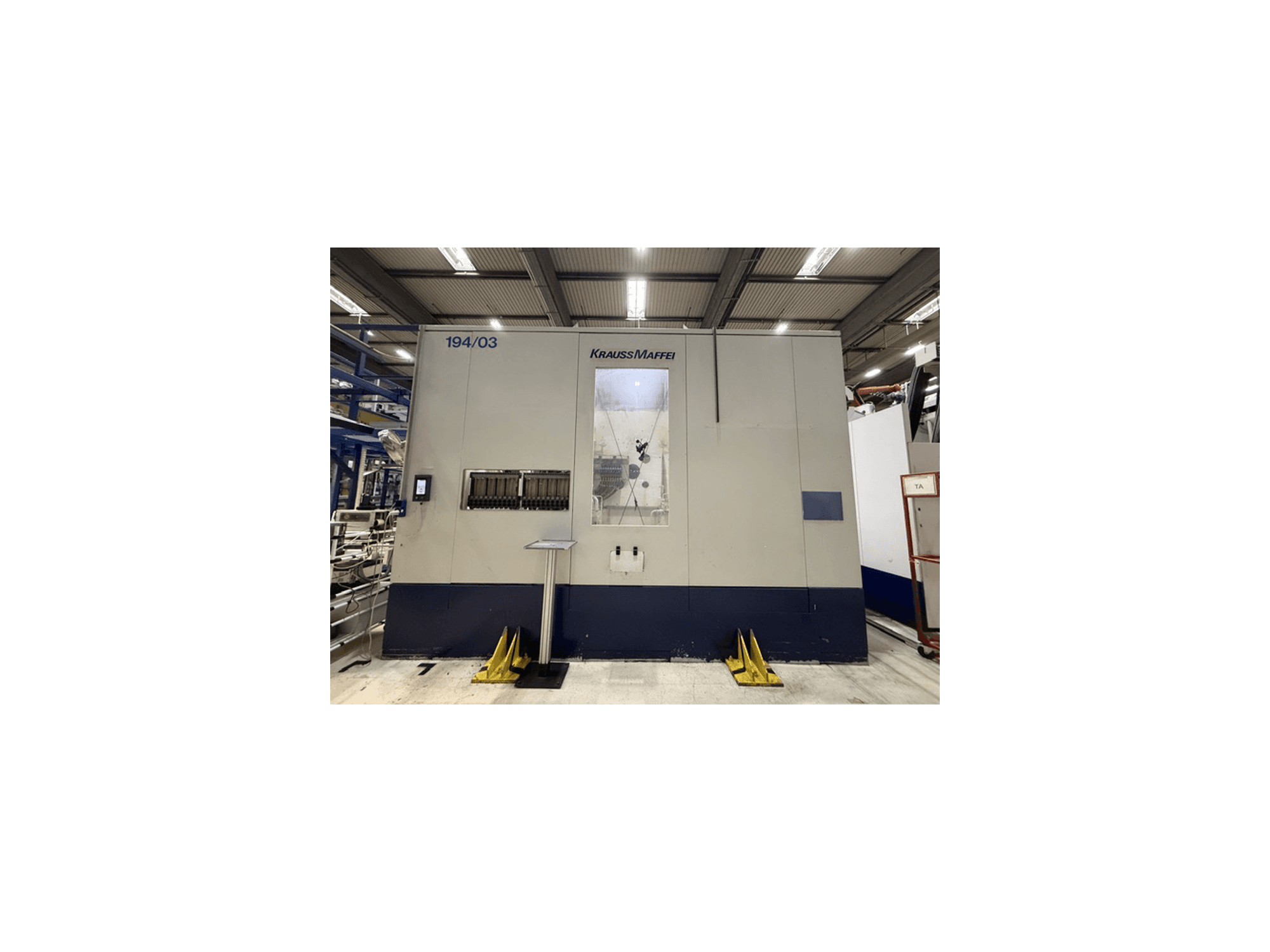 „Krauss Maffei 4000-24500 MC“ hidraulinė liejimo mašina, vaizdas iš priekio, kuriame matomas valdymo skydas ir darbo zona.