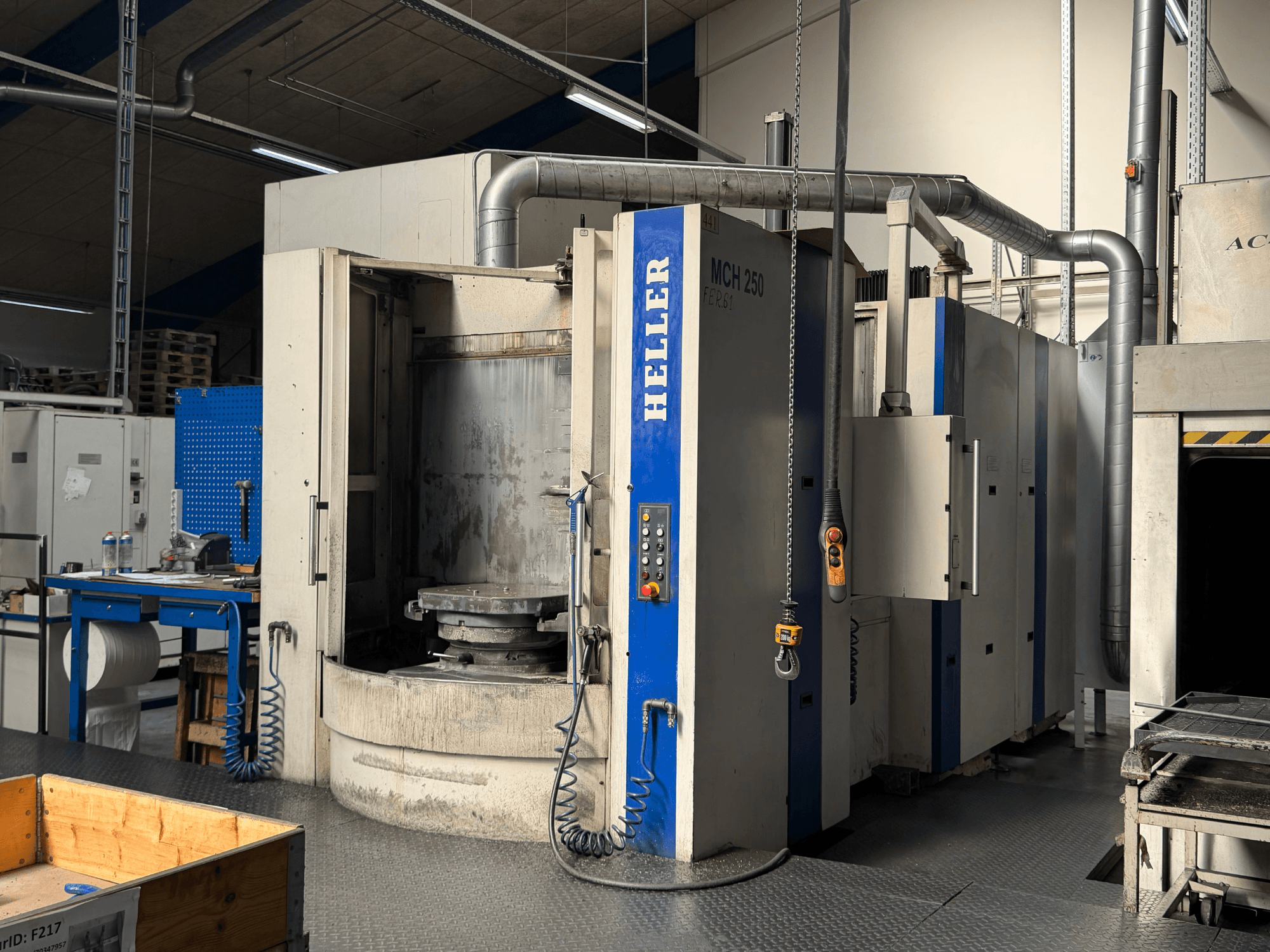 Horizontalaus apdirbimo centro HELLER MCH 250 vaizdas iš priekio su valdymo pultu, dideliu sukamuoju stalu ir pramonine aplinka.