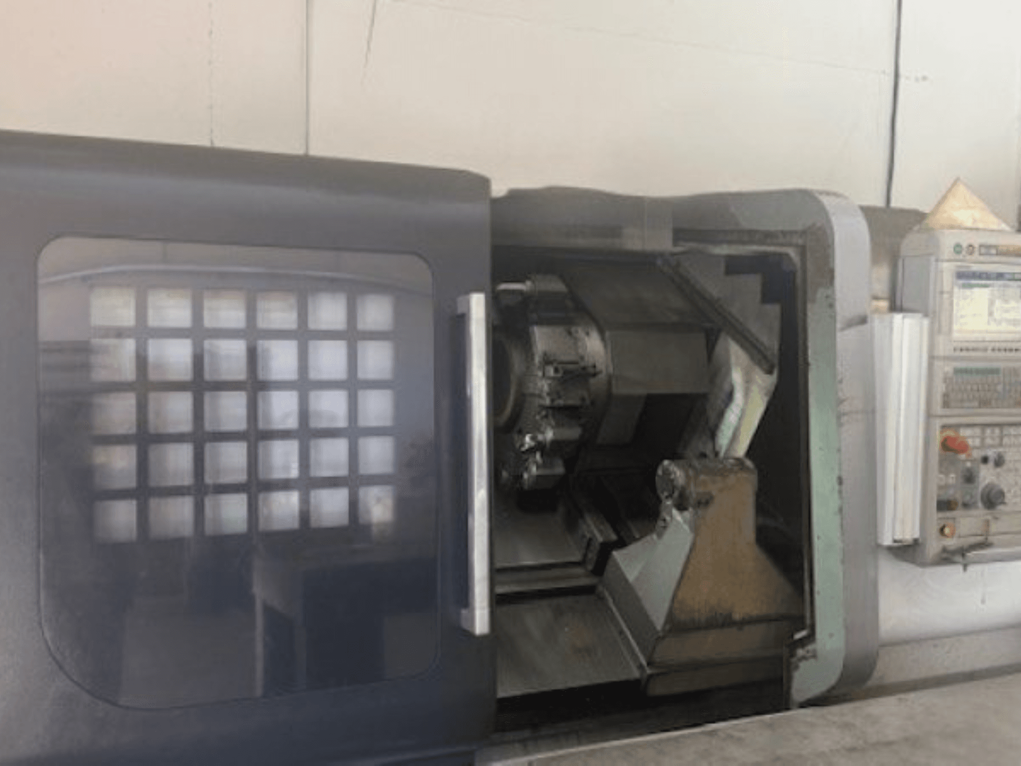 MORI SEIKI NLX 2500M horizontalios tekinimo staklės, priekinis vaizdas, rodantis įrankių laikiklį, valdymo skydelį ir vidinį mechanizmą.