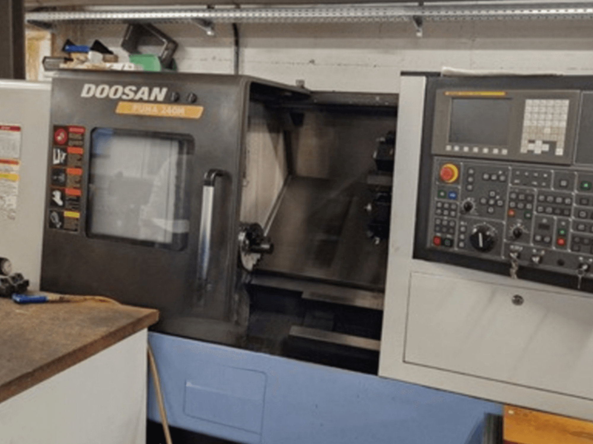 Horizontaliųjų tekinimo staklių DOOSAN Puma 240MB priekinis vaizdas, kuriame matomas valdymo skydelis ir darbinės funkcijos.