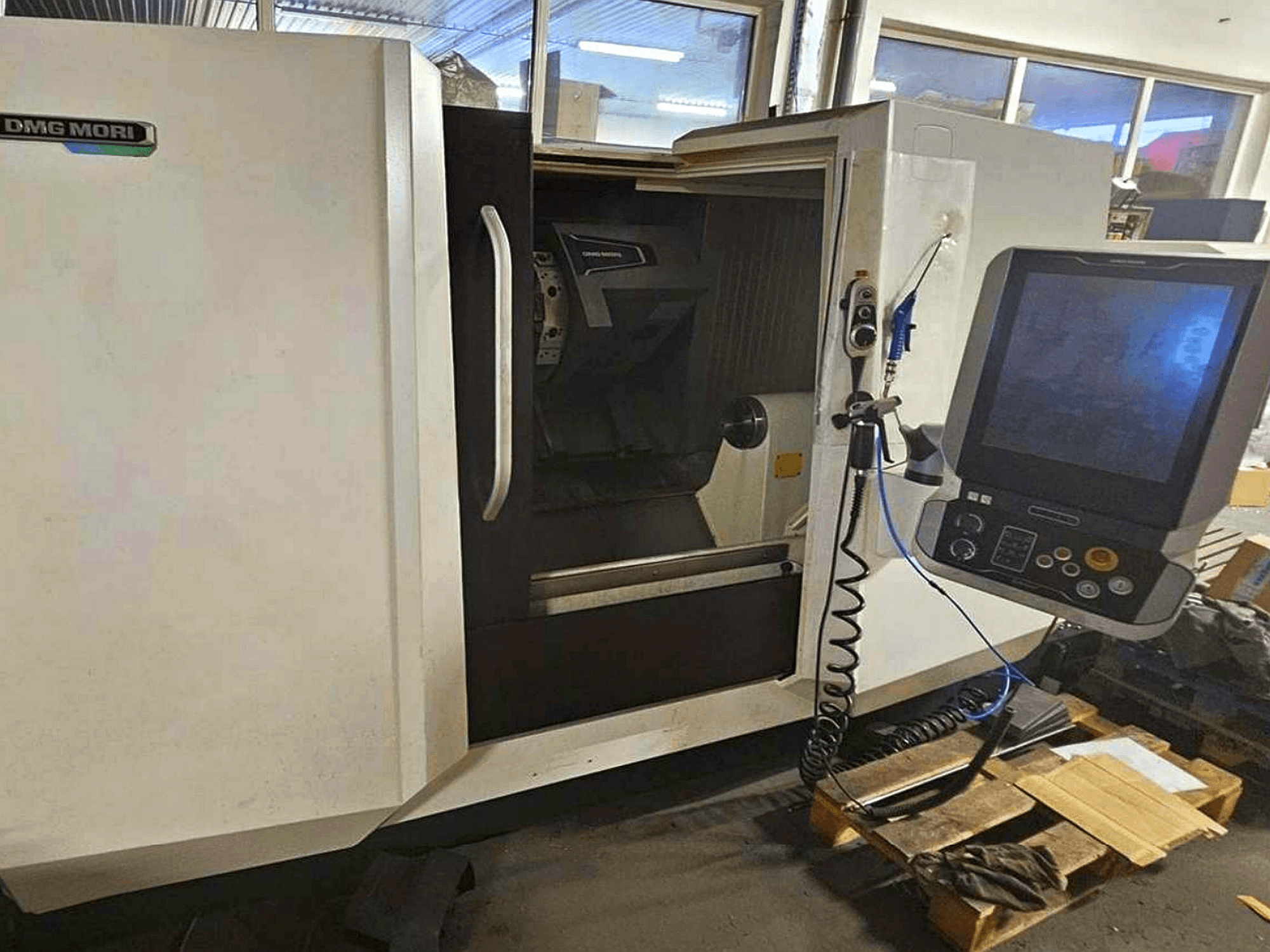 DMG MORI CLX 450 V4 horizontalios tekinimo staklės, vaizdas iš priekio su valdymo skydeliu, kuriame matyti darbo vieta ir korpuso dizainas.