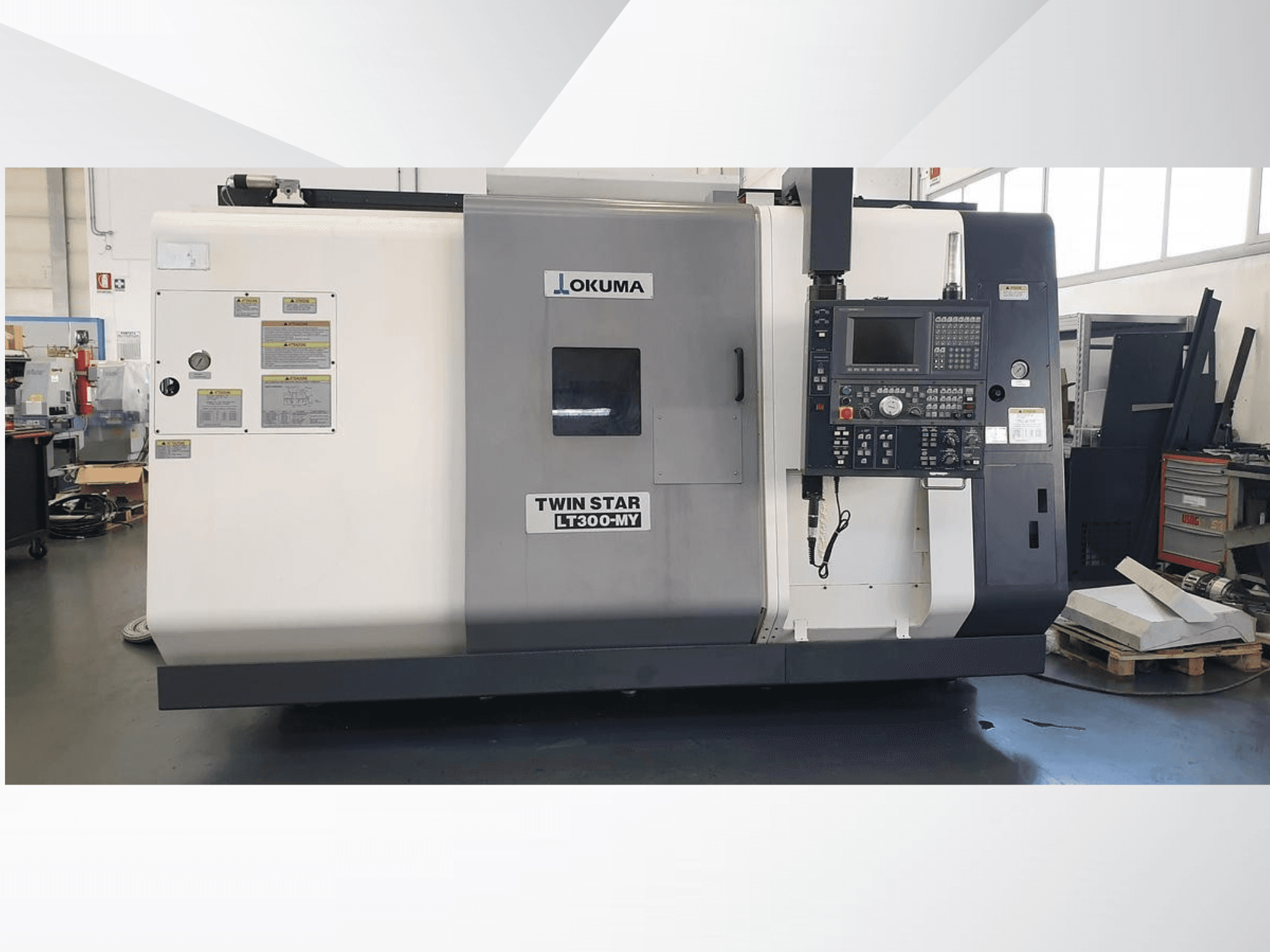 Okuma Twin Star LT300-MY CNC tekinimo staklės, vaizdas iš priekio, matomas valdymo skydelis ir darbinės etiketės.