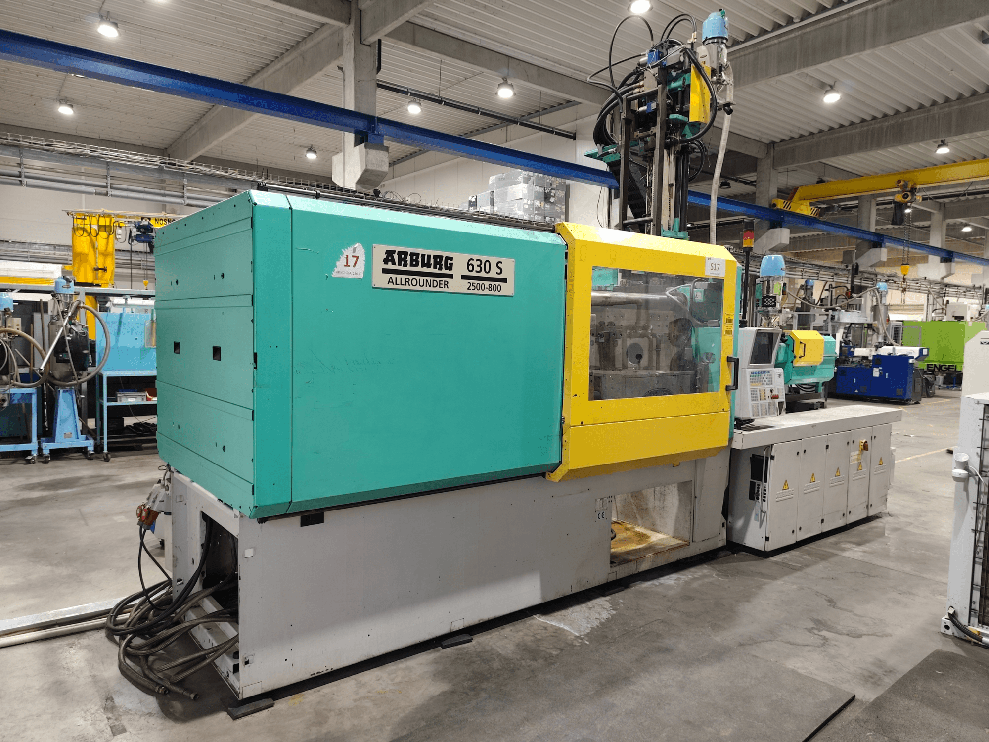 „Arburg Allrounder 630S-2500-800/350“ hidraulinė liejimo mašina, vaizdas iš šono, matomas spalvingas korpusas ir valdymo pultas.