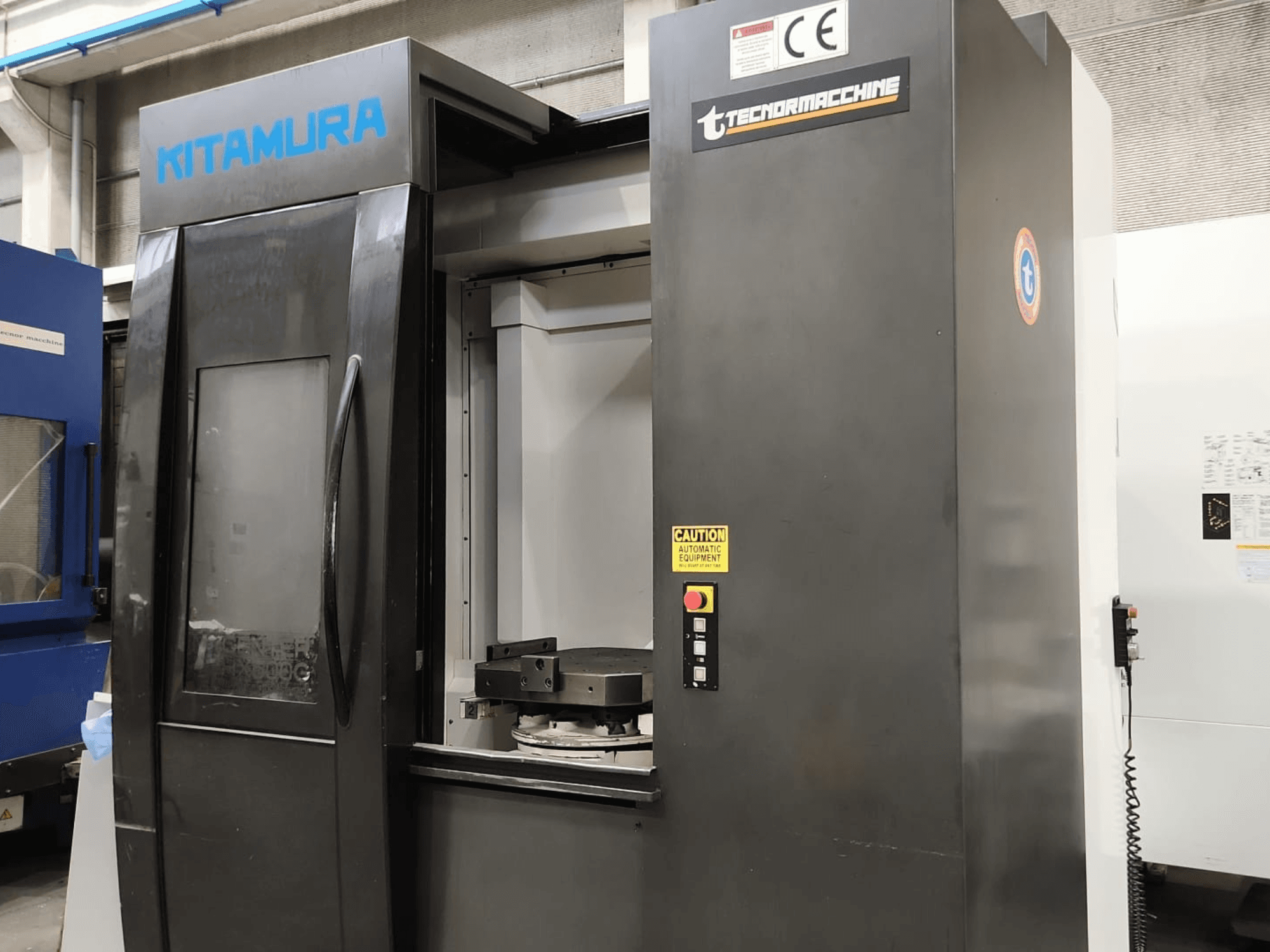 Horizontalus apdirbimo centras „Kitamura Mycenter HX500iG“, vaizdas iš priekio, kuriame matomas valdymo pultas ir darbo zona.
