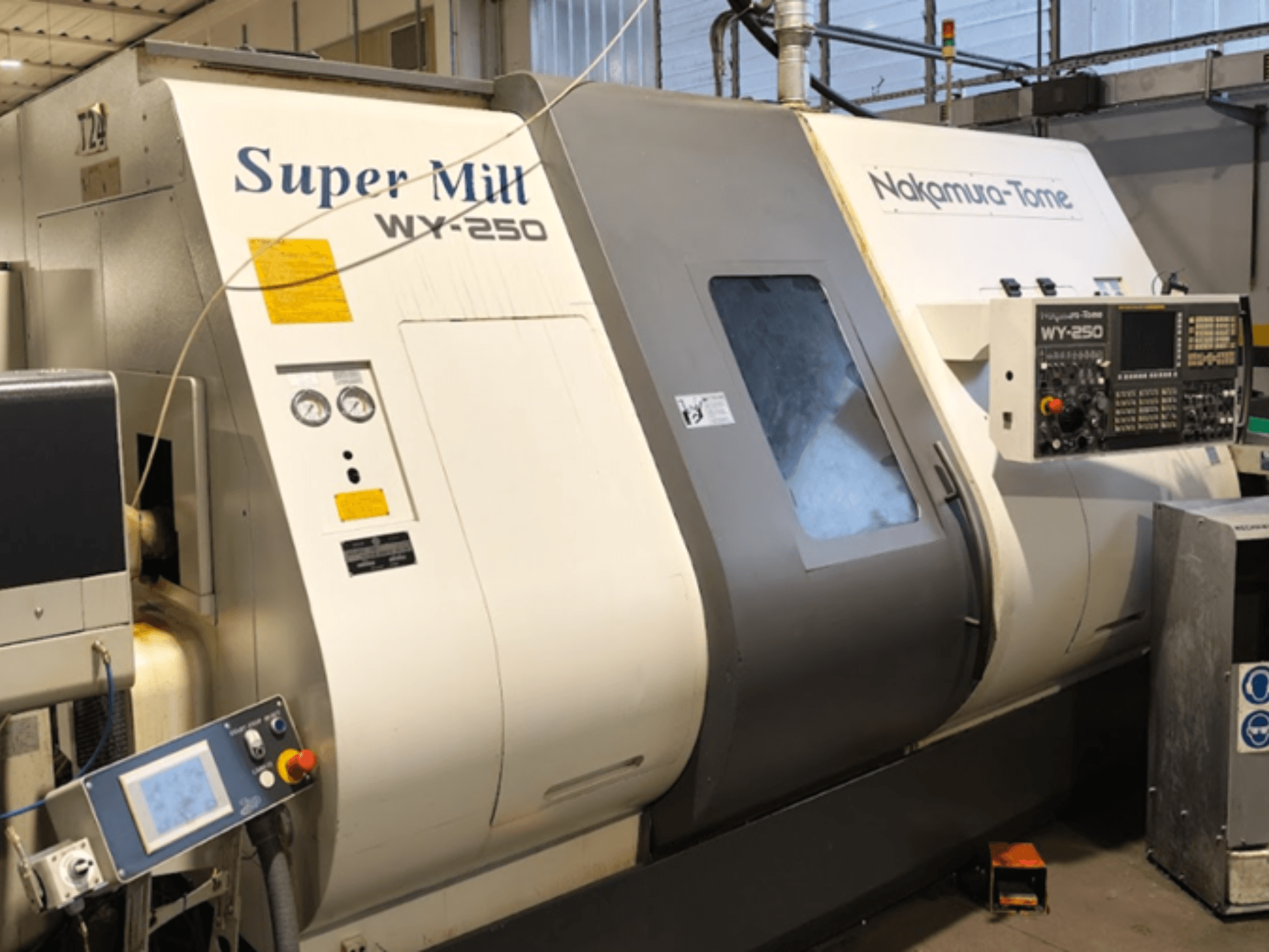 Horizontalios tekinimo staklės NAKAMURA-TOME WY 250 iš priekio; valdymo skydelis ir ekranas su užrašu "Super Mill".
