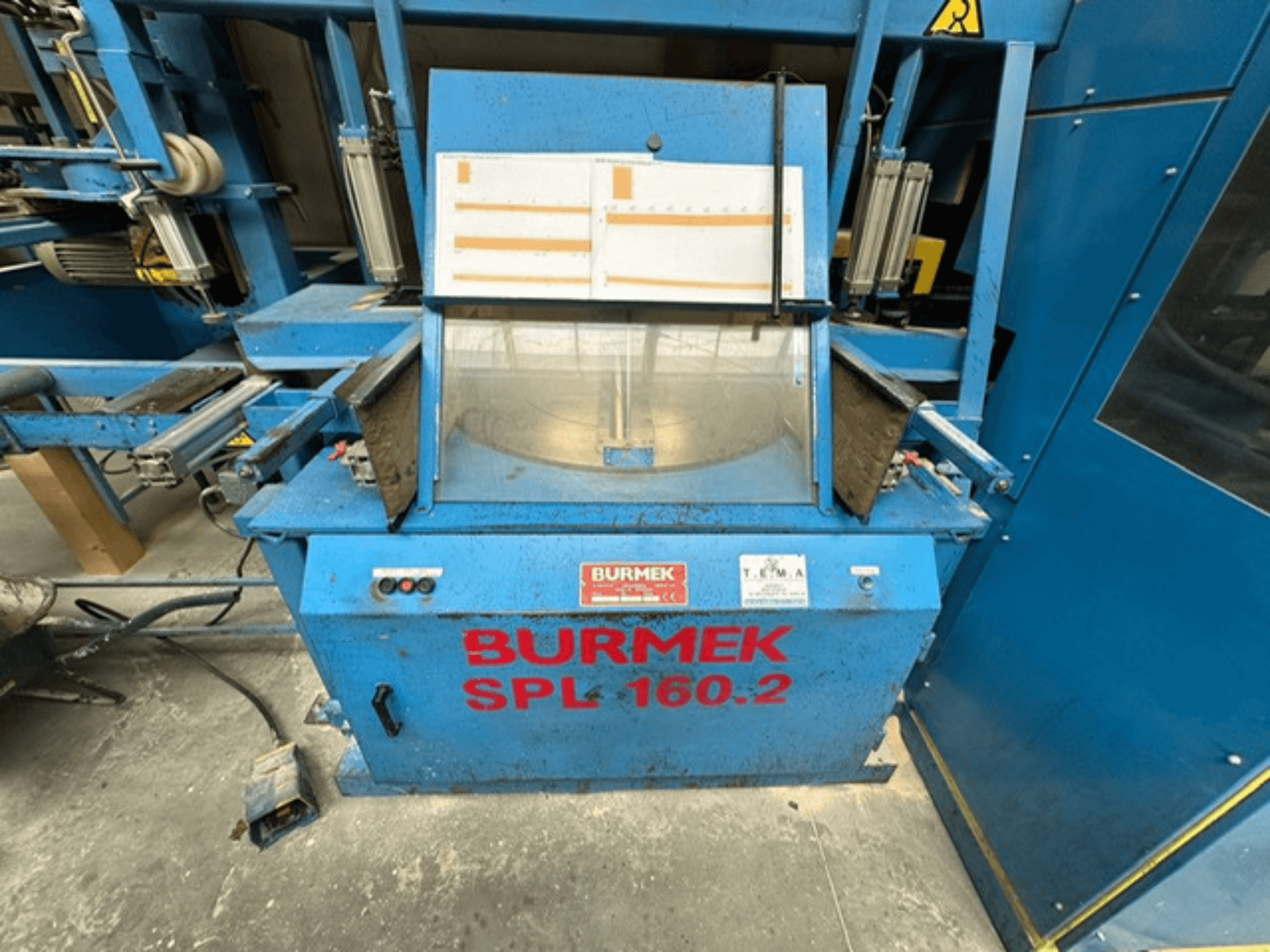 Mėlynos spalvos BURMEK SPL 160.2 medžio staklės, vaizdas iš priekio, su valdymo mygtukais ir stikliniu skydeliu, kuriame matomas vidus.