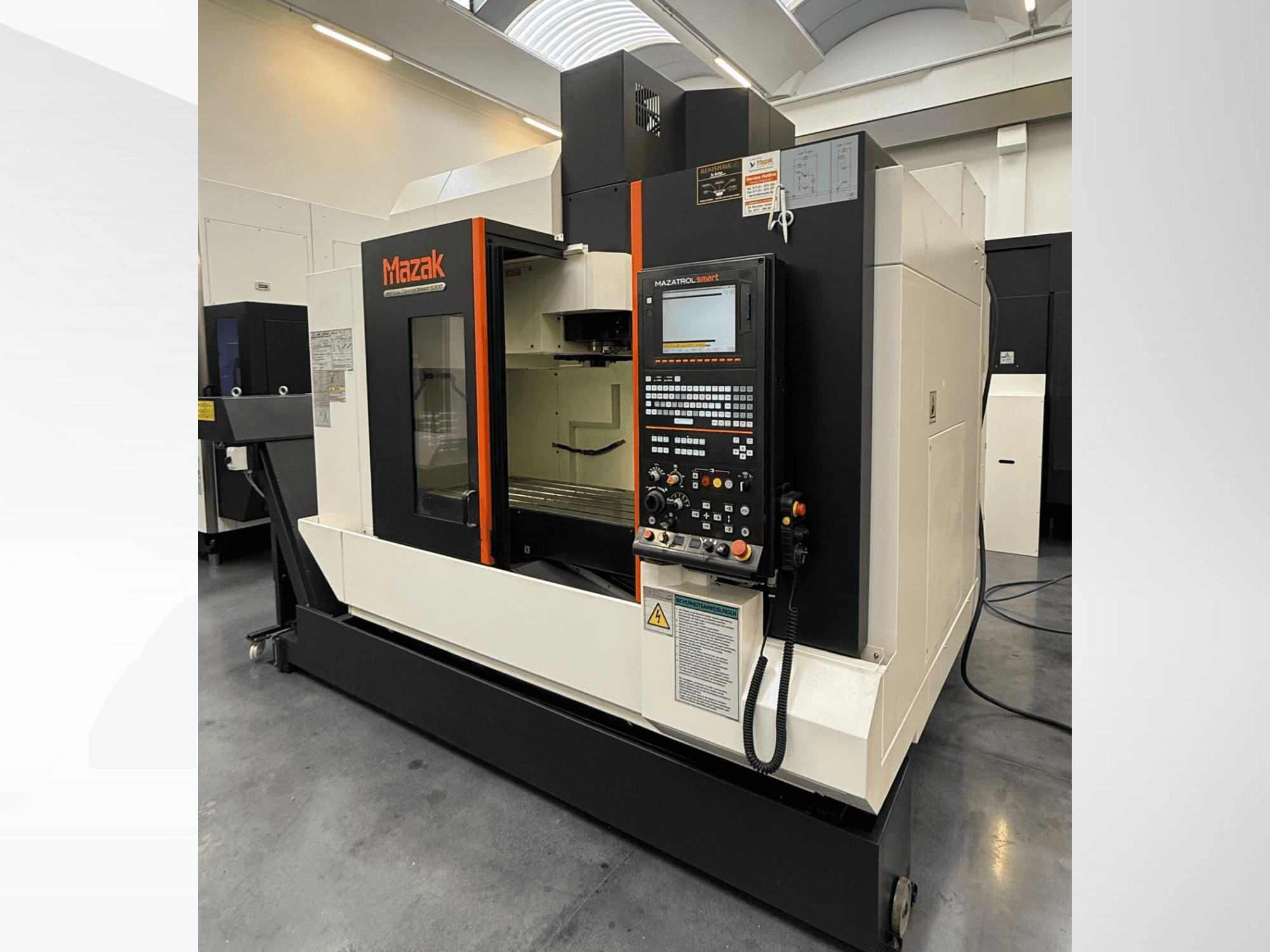 Mazak CNC staklės, vaizdas iš priekio, su valdymo pultu ir erdvia darbo zona su tikslaus pjovimo įrankiais.