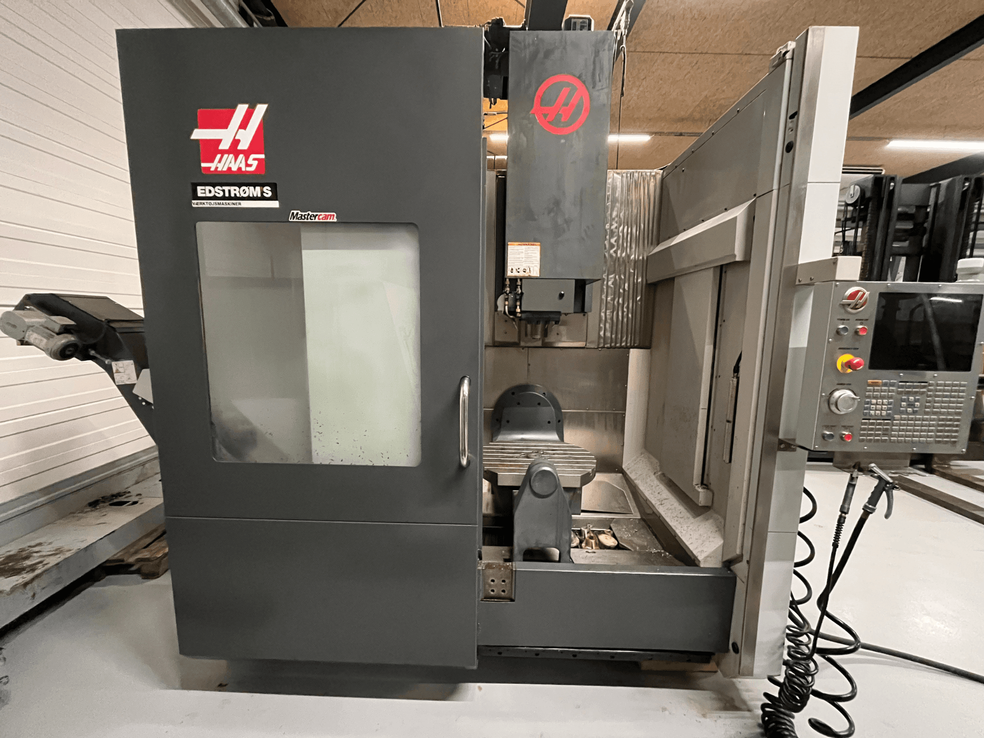 Haas EDSTROM S CNC staklių priekinis vaizdas, kuriame matyti valdymo skydelis, suklio galvutė ir apdirbimo stalas.