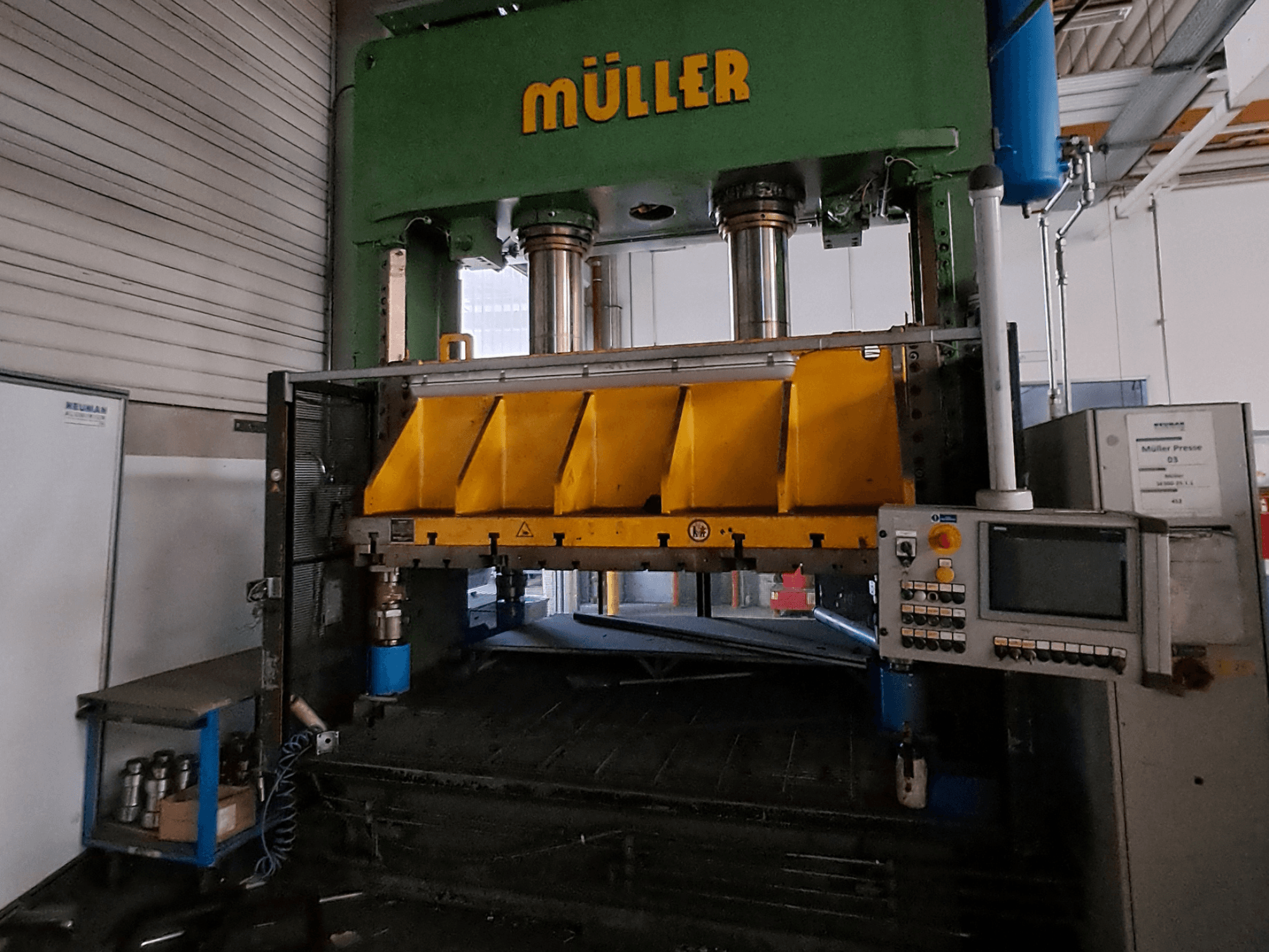 „Müller SE 300-25.1.1“ metalo presavimo staklių vaizdas iš priekio, kuriame matomi geltoni presavimo komponentai ir šone esantis valdymo pultas.