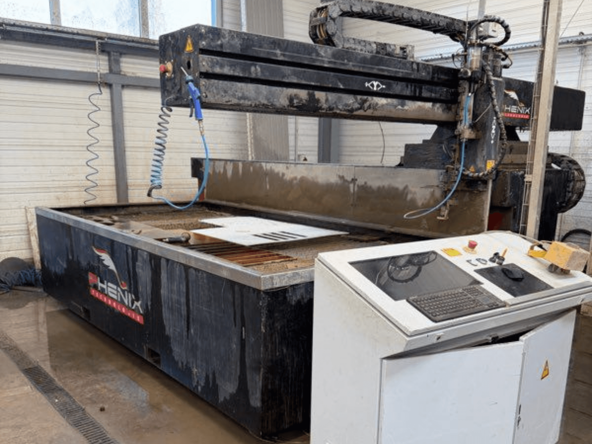 PHENIX MD JET 1530 pjovimo vandens srove staklės, priekinis vaizdas, kuriame matomas valdymo skydelis ir pjovimo zona su matomu vandens rezervuaru.