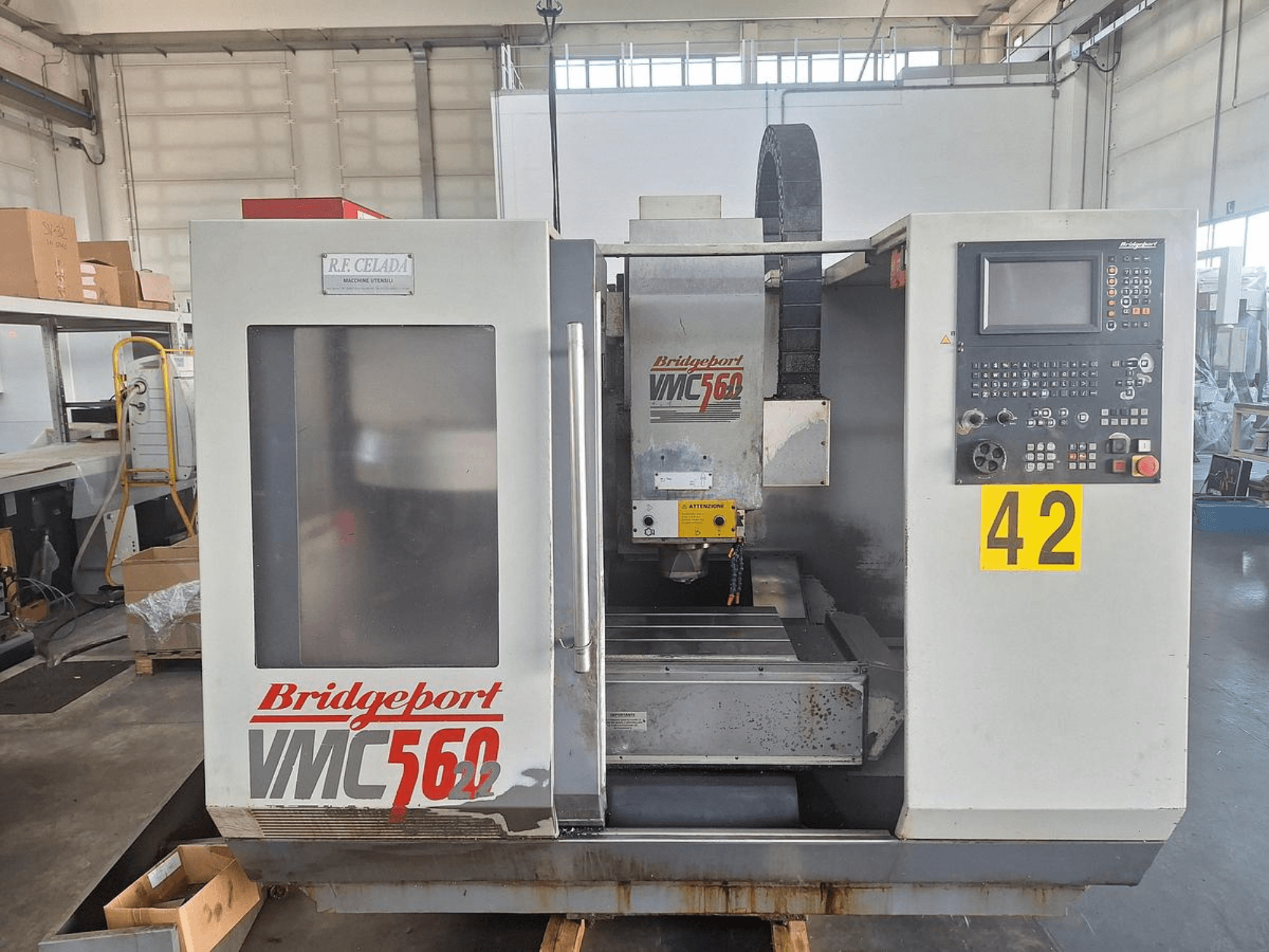 Vertikalus apdirbimo centras „Bridgeport VMC 560/22“, vaizdas iš priekio, kuriame matomas valdymo pultas, įrankių laikiklis ir darbo zona.