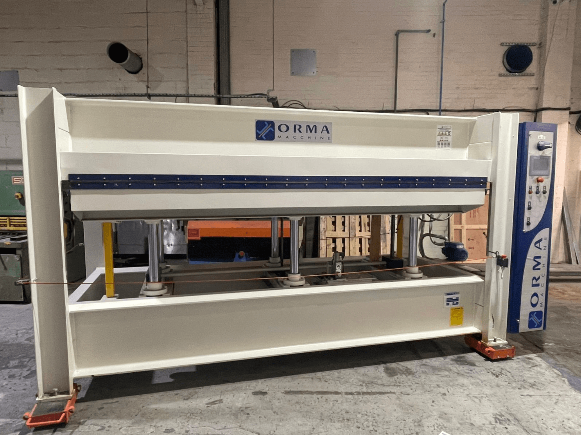 Hidraulinis presas "ORMA machinery", vaizdas iš priekio, sidabrinė apdaila, valdymo skydelis dešinėje ir vertikalūs presavimo stūmokliai.
