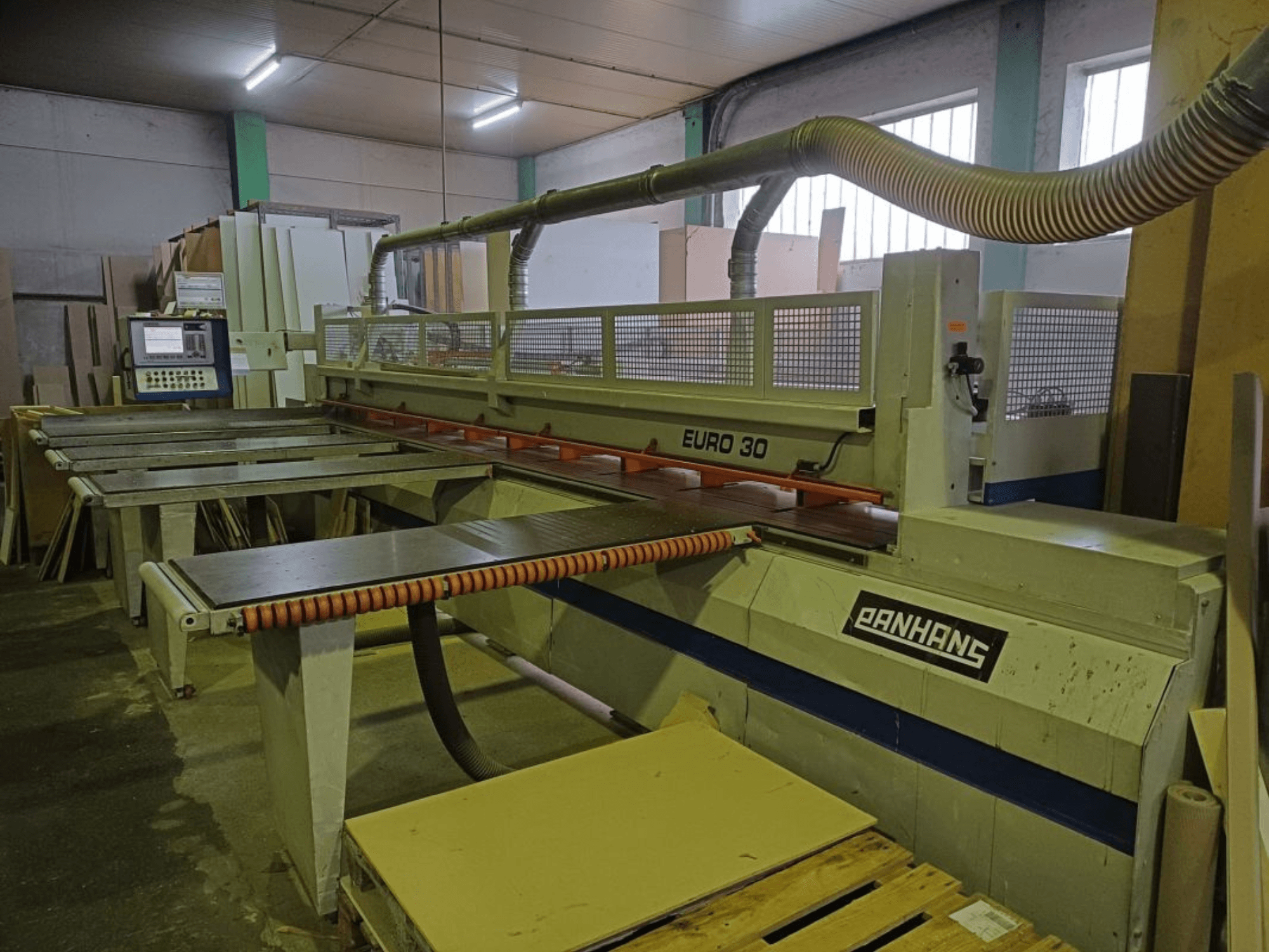 PANHANS EURO 30 plokščių pjūklo su valdymo pultu, pjovimo stalu ir dulkių nusiurbimo žarna dirbtuvėse vaizdas iš priekio.