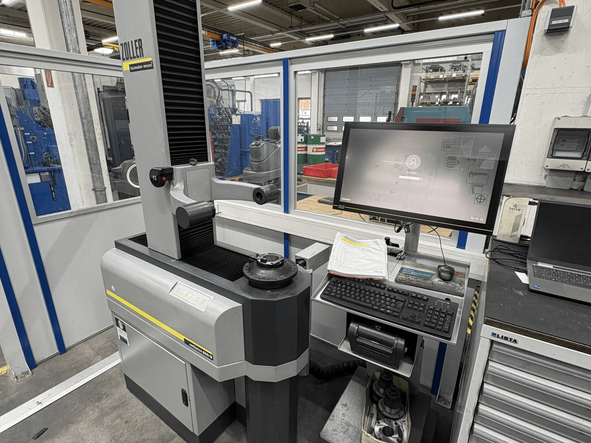 Optinė matavimo mašina "Zoller Venturion 600/8" dirbtuvėse su monitoriumi, klaviatūra ir matavimo platforma šoniniame vaizde.