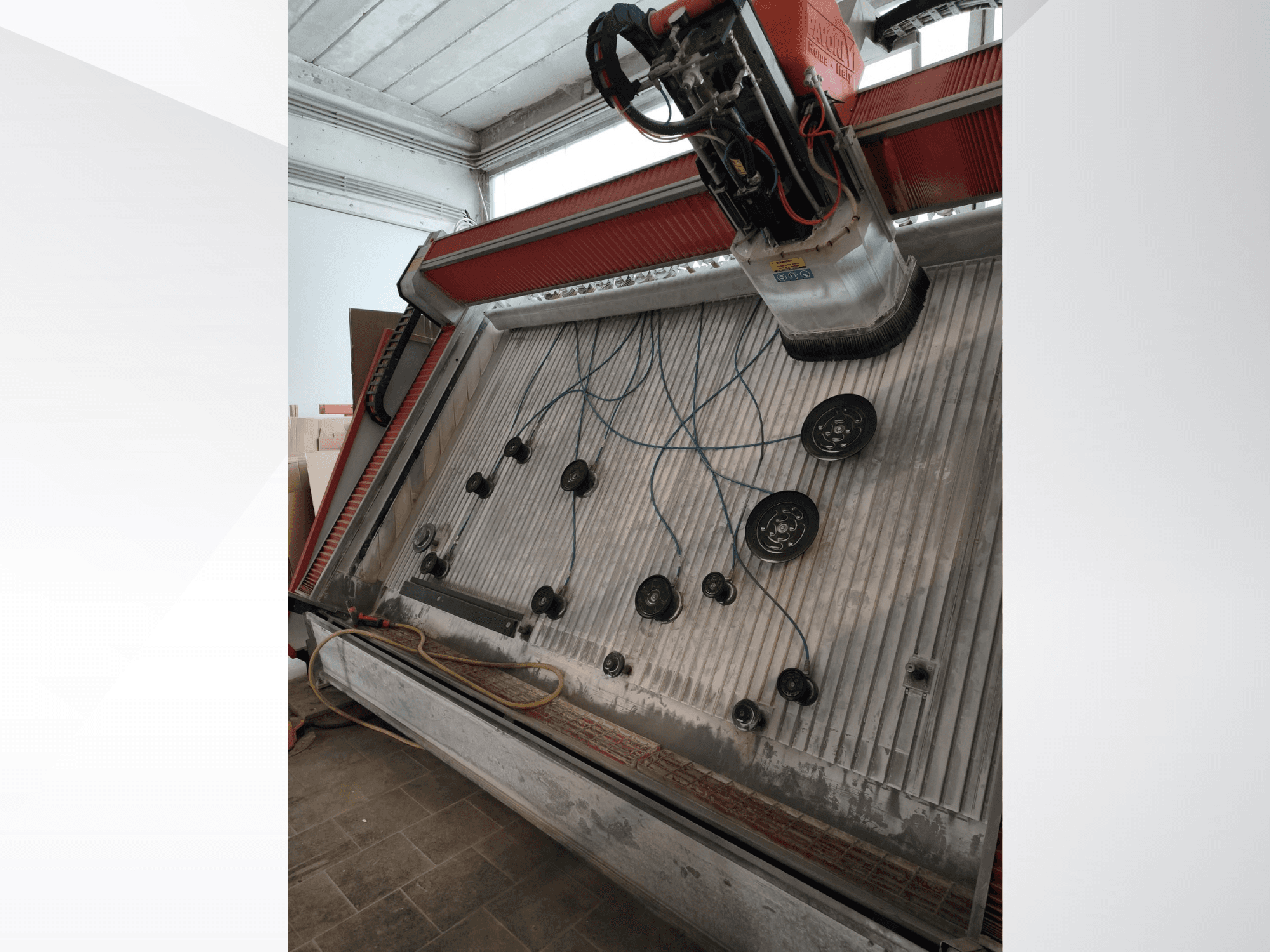 Vertikalus apdirbimo centras „PAVONI V2400 Open Top“, vaizdas iš šono, kuriame matoma darbo zona ir mechaniniai komponentai.