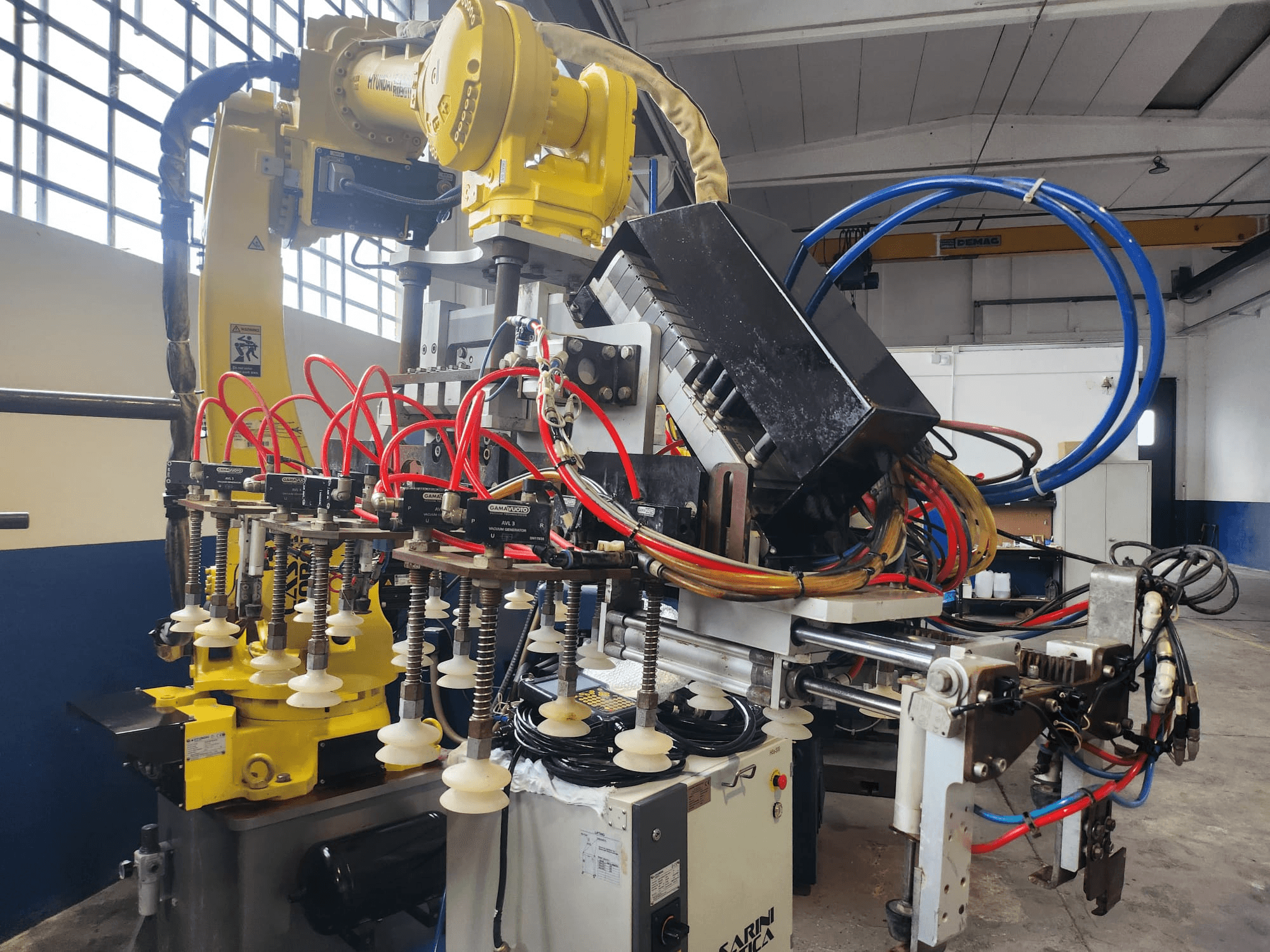 "Hyundai Hi 5a-S" roboto rankos vaizdas iš priekio: daugybė žarnų, valdymo komponentų ir sudėtingas kabelių išdėstymas.