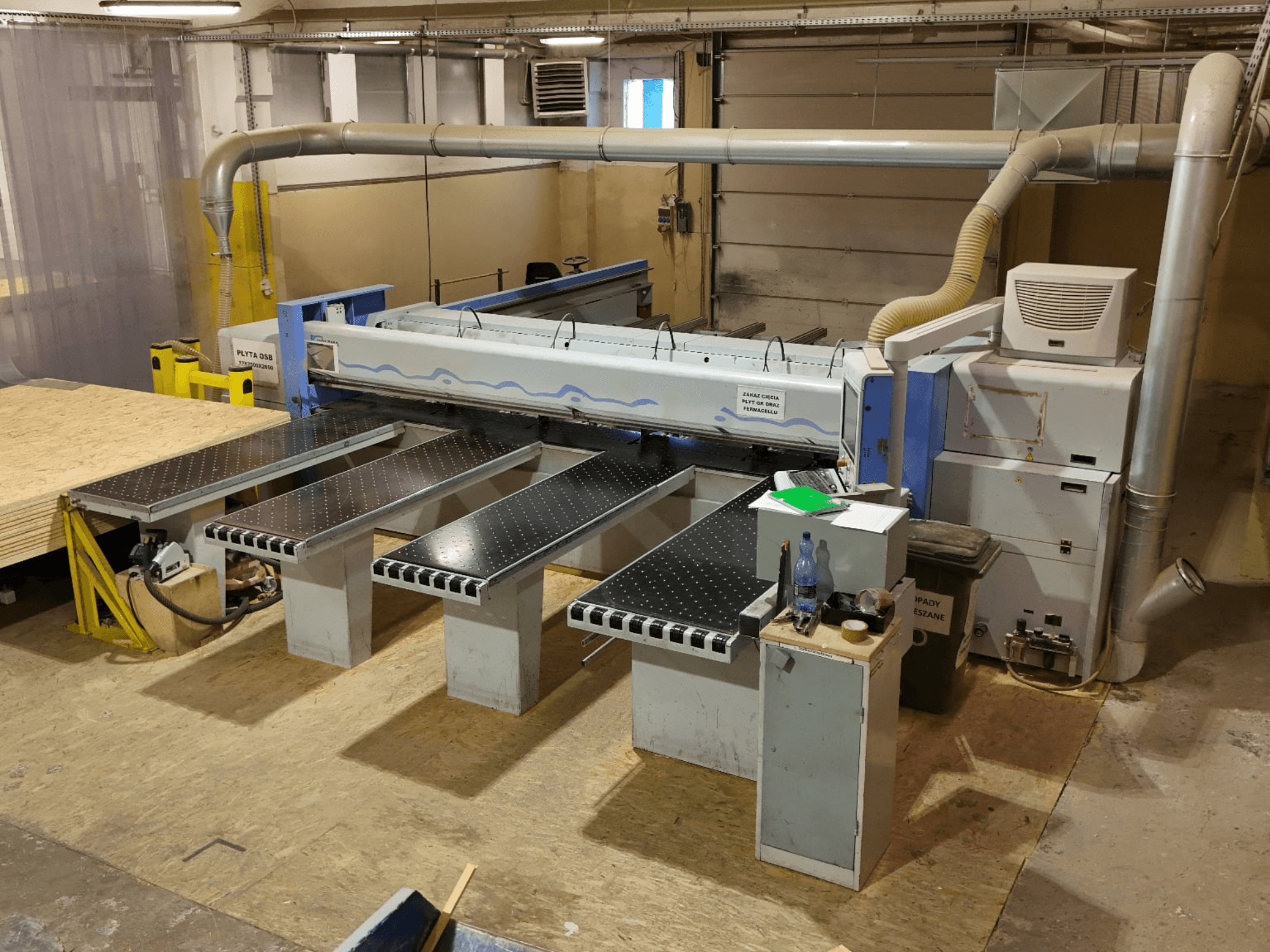 HOLZMA HPP 350/43/38 plokščių pjovimo staklės dirbtuvėse, vaizdas iš viršaus, kuriame matoma pjovimo zona ir atraminiai stalai.