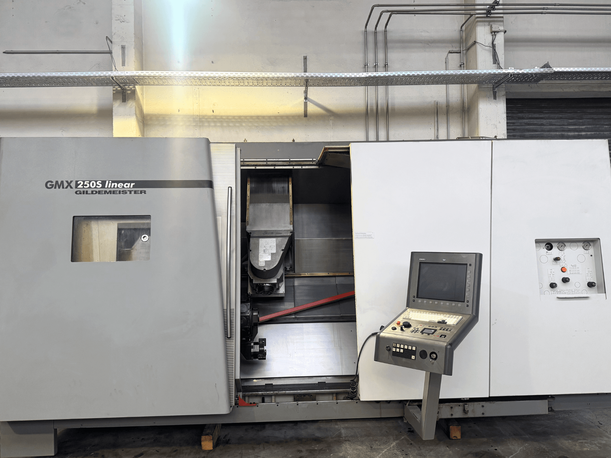 Gildemeister GMX 250S linijinės CNC staklės, vaizdas iš priekio, matomas valdymo skydelis ir atvira darbo zona.