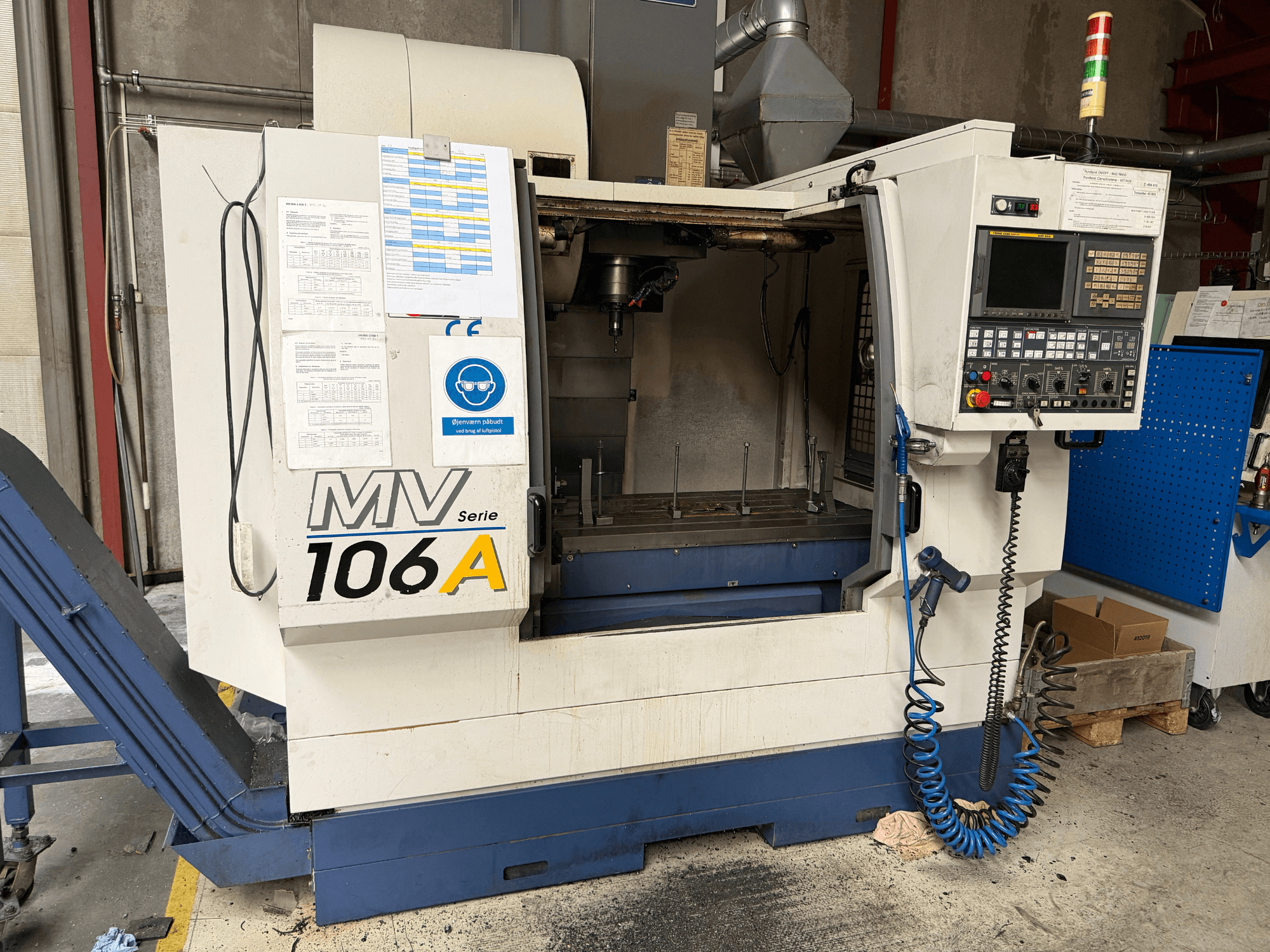 Vertikalusis apdirbimo centras „YCM MV106A“, vaizdas iš priekio, kuriame matomas valdymo pultas ir darbo erdvė, su pridėta technine dokumentacija.