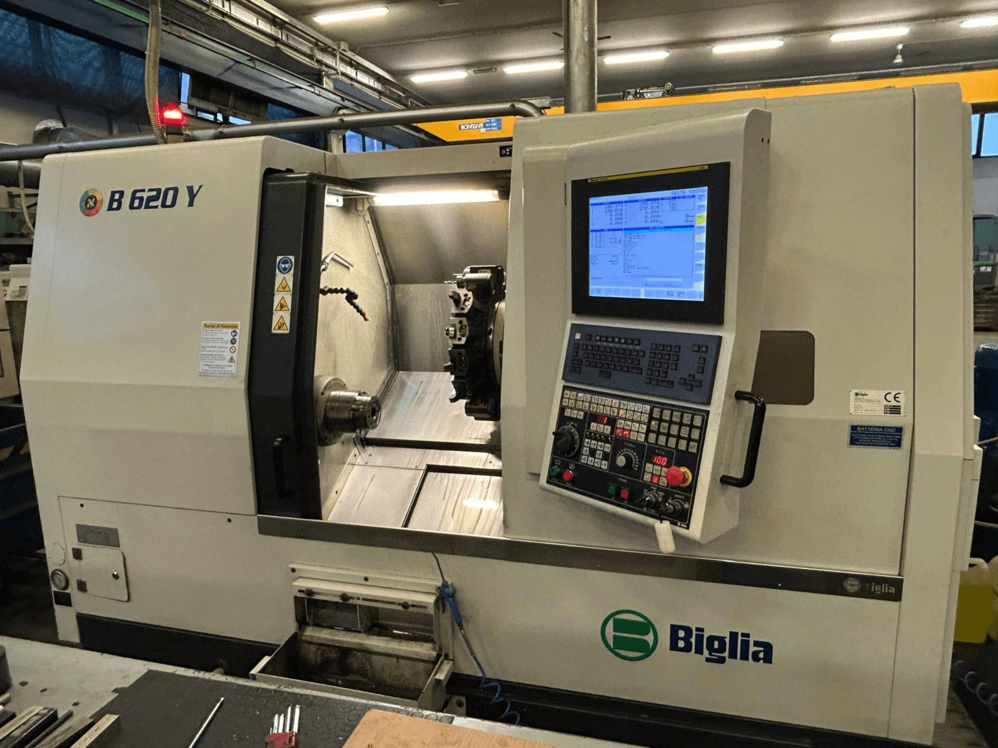 Biglia B 620 Y CNC staklės dirbtuvėse, vaizdas iš priekio, kuriame matomas valdymo skydelis su skaitmeniniu ekranu ir apdirbimo komponentai.