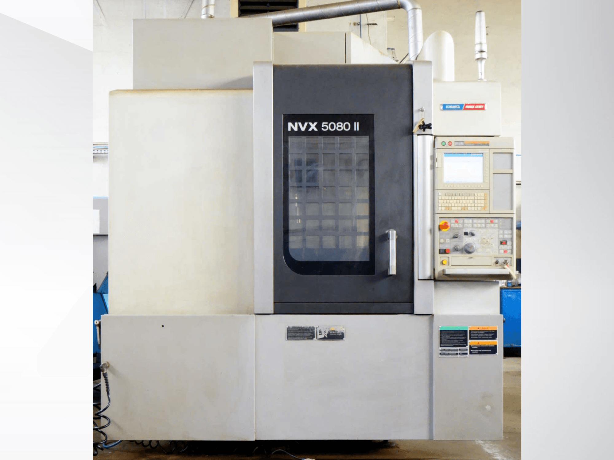 DMG Mori Seiki NVX 5080 II vertikalus apdirbimo centras, vaizdas iš priekio, su valdymo pultu ir grotelinėmis durimis.
