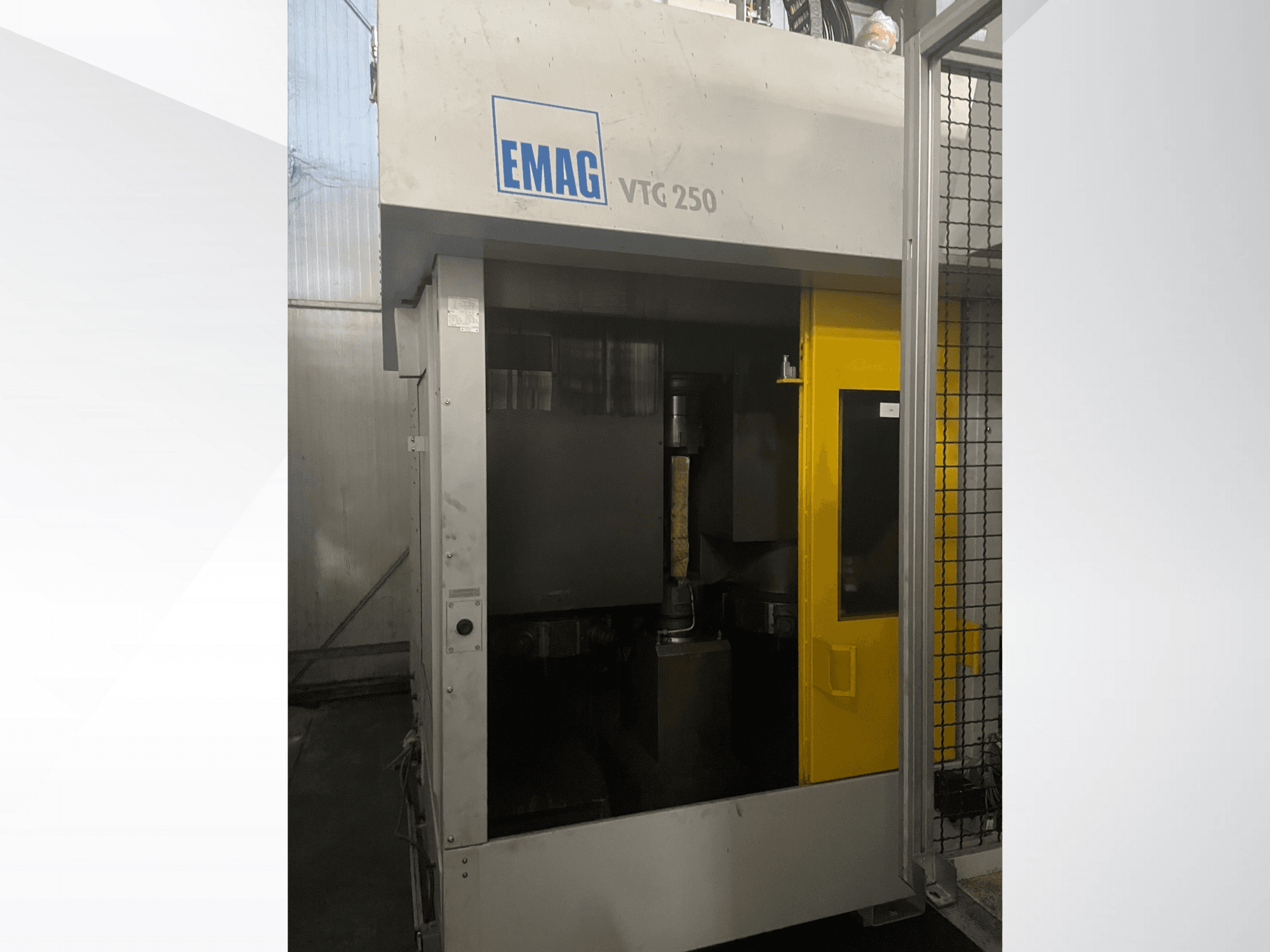 Vertikalaus apdirbimo centro EMAG VTC 250 vaizdas iš priekio: geltonos durys ir matomas pjovimo įrankis kameroje.