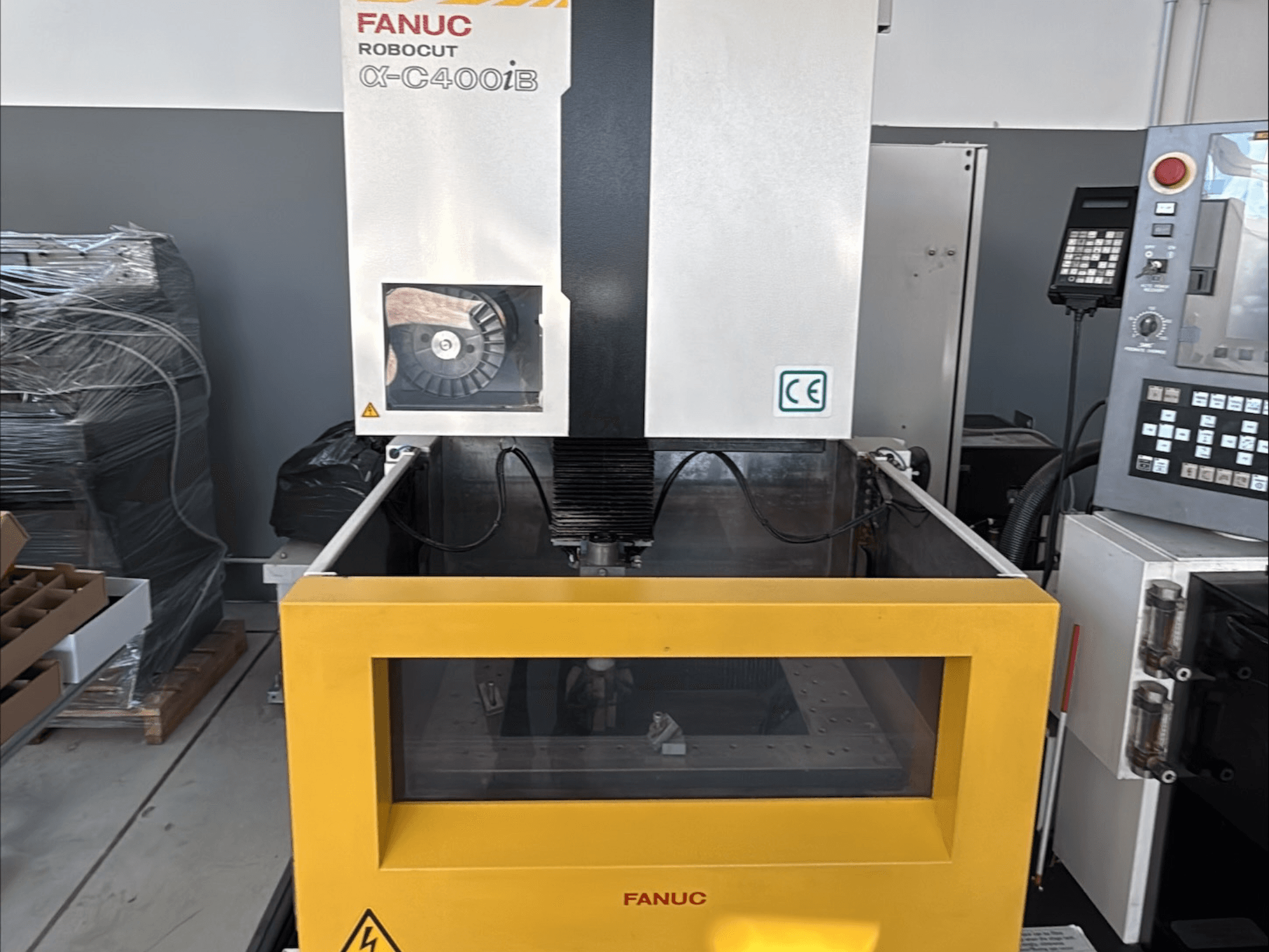 FANUC Robocut α-C400iB vielos elektroerozijos staklės, vaizdas iš priekio, geltonas bakas ir valdymo skydelis.